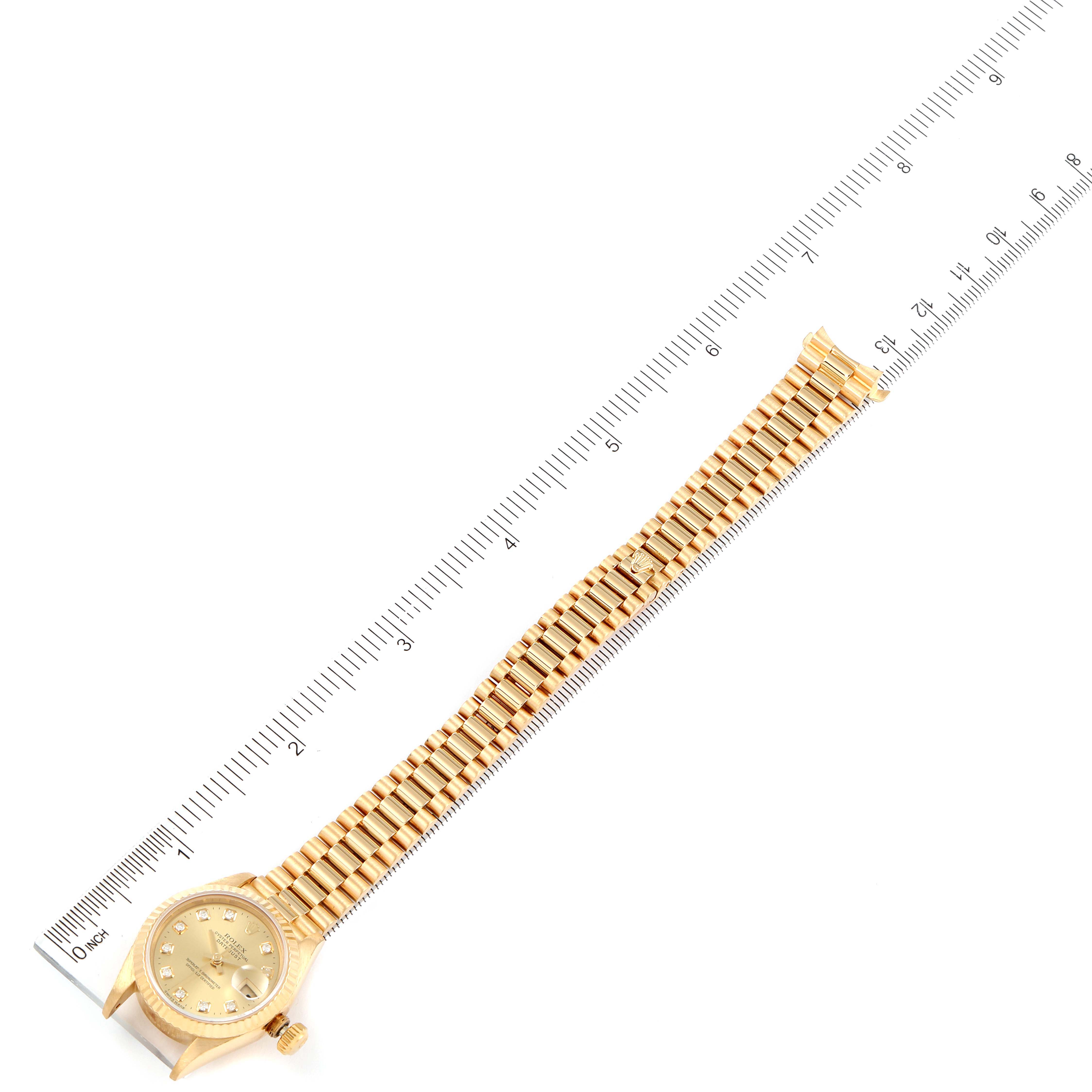 The Rolex President 69178 Women
s Yellow Gold Champagne Dial 69178 Women
s Yellow Gold Champagne Dial model watch is shown fully extended next to a ruler, displaying the entire band and face from an overhead angle.
