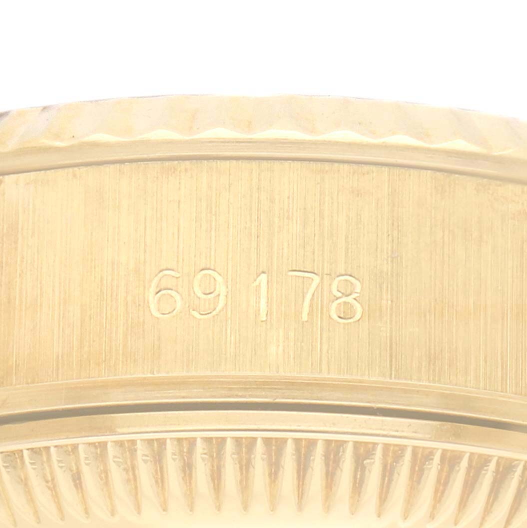 The image shows a close-up of the side of a Rolex President 69178 Women
s Yellow Gold Champagne Dial 69178 Women
s Yellow Gold Champagne Dial model, focusing on its serial or model number and the watch bezel.