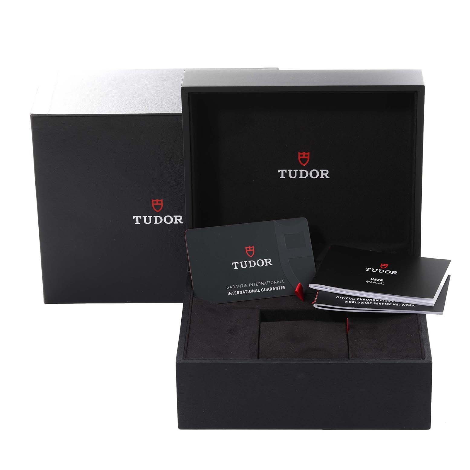 The image shows the packaging, warranty card, and manuals for a Heritage Black Bay model by Tudor.