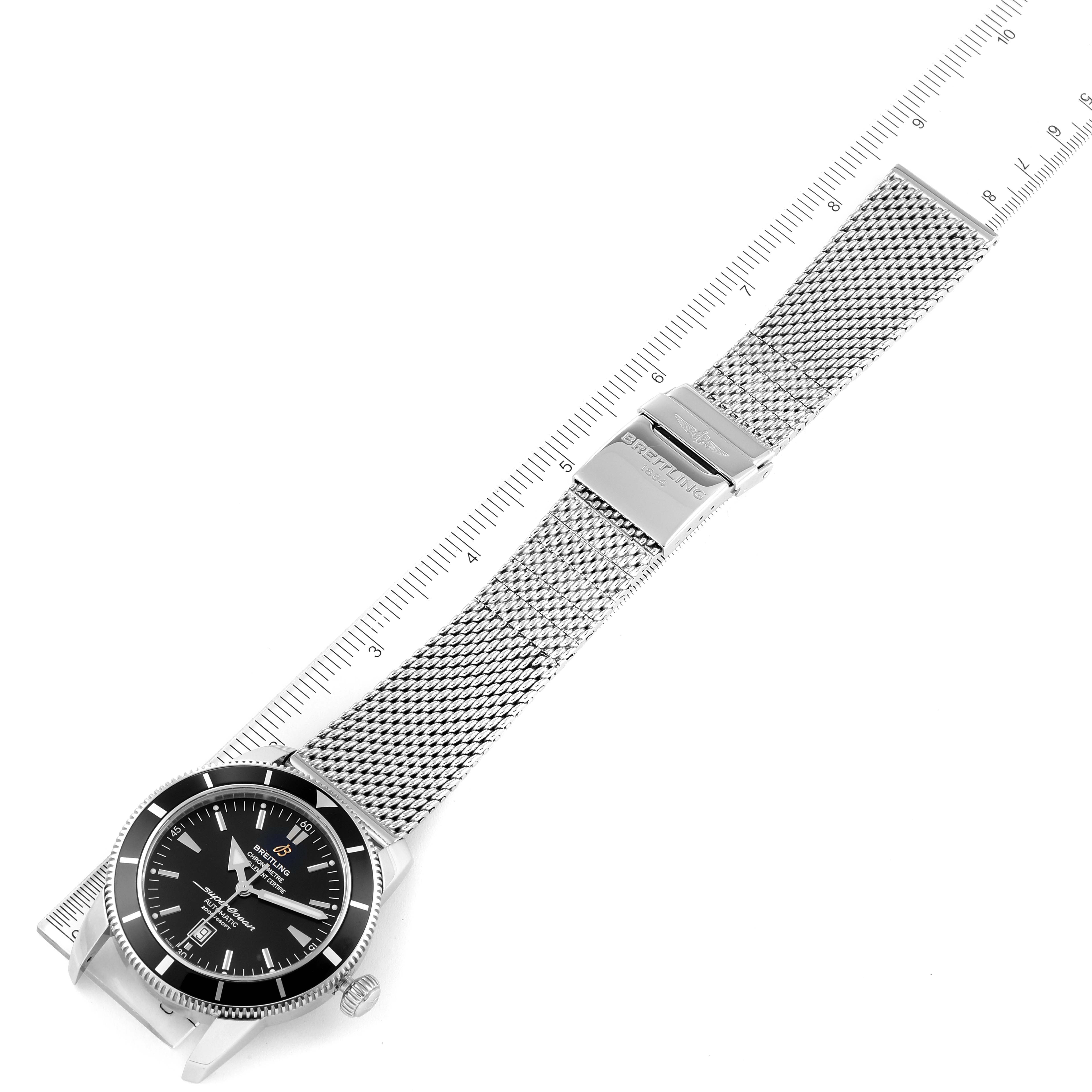 The image shows a Breitling Superocean A17320 Men's Stainless Steel Black Dial A17320 Men's Stainless Steel Black Dial watch horizontally with its mesh bracelet aligned with a ruler.