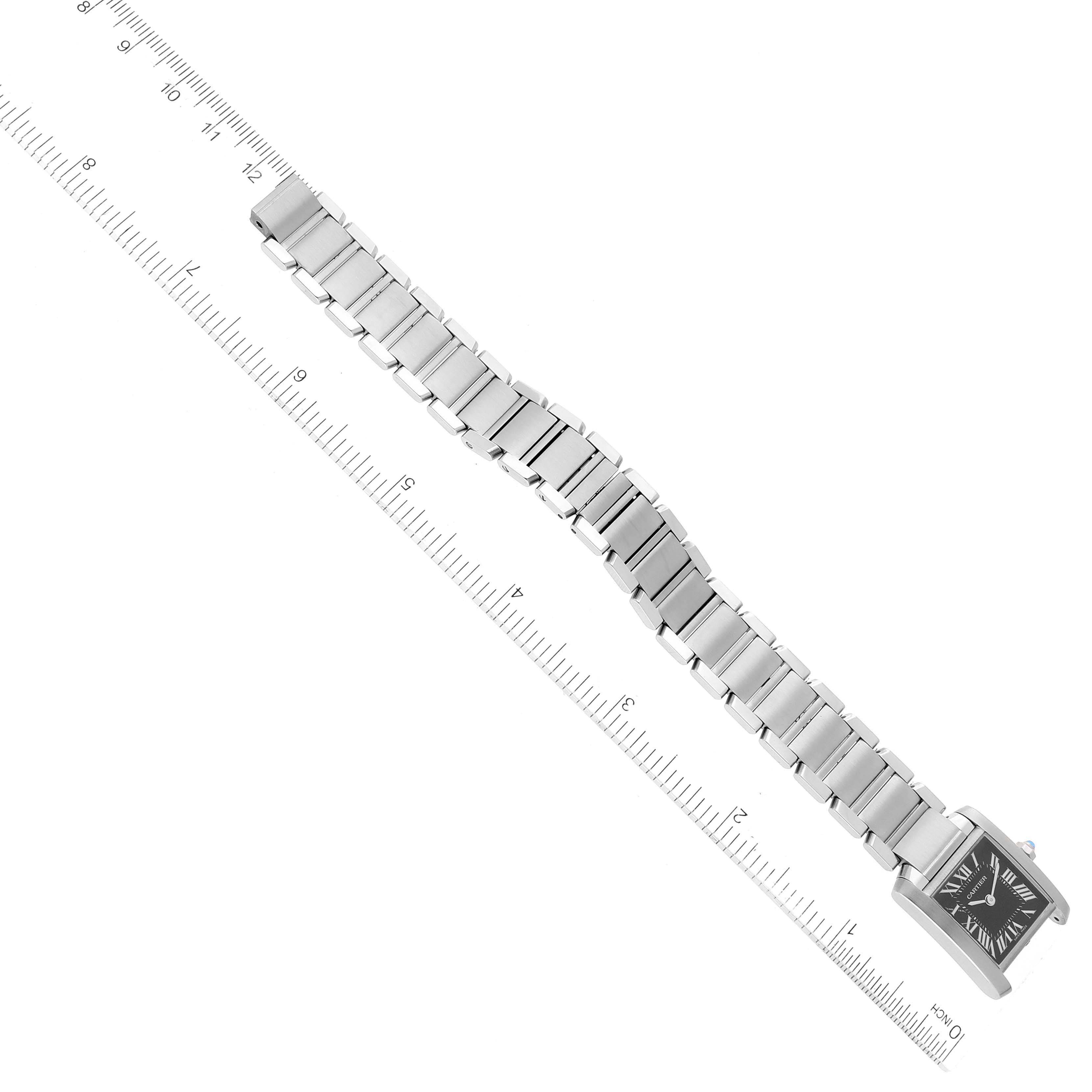 The image shows a top view of a Cartier Tank Francaise W51026Q3 Women's Stainless Steel Black Dial W51026Q3 Women's Stainless Steel Black Dial watch with its bracelet aligned next to a ruler.