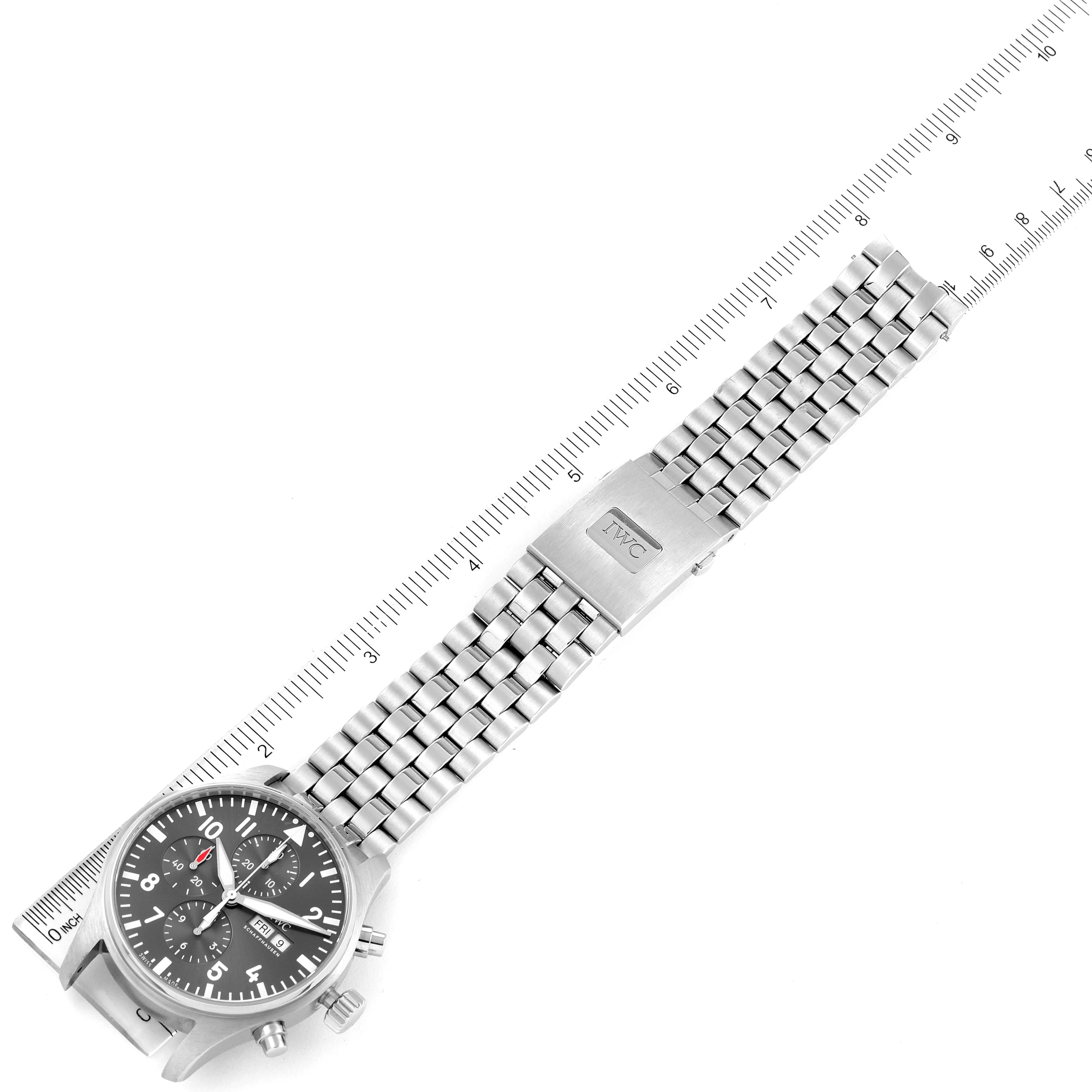 The IWC Pilot IW388102 Men's Stainless Steel Grey Dial IW388102 Men's Stainless Steel Grey Dial model watch is shown laid flat with a ruler, displaying the watch face, buttons, and the metal bracelet.