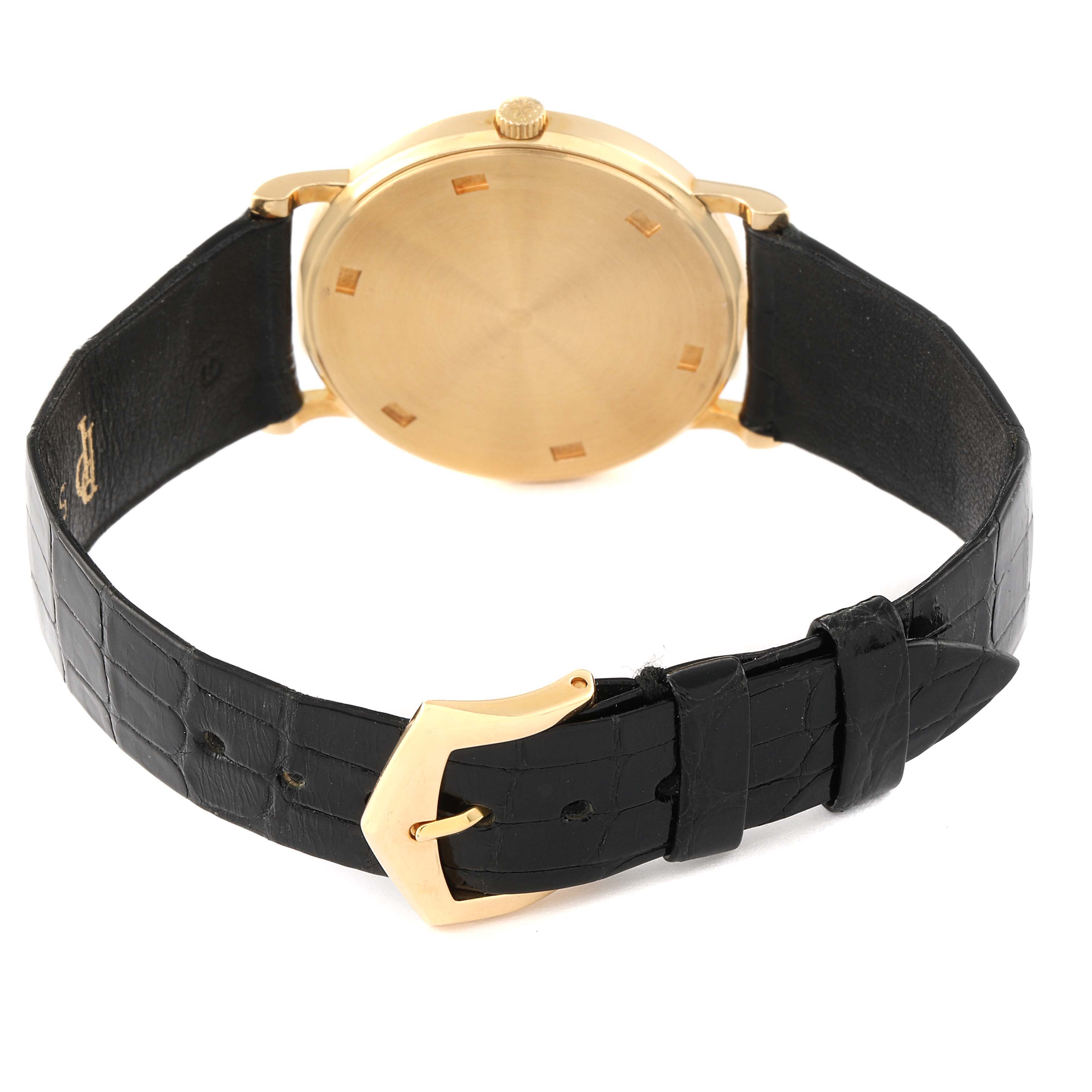 The image shows the back of a Patek Philippe Calatrava 3520 Men's Yellow Gold White Dial 3520 Men's Yellow Gold White Dial watch with a gold case and a black leather strap with a gold buckle.