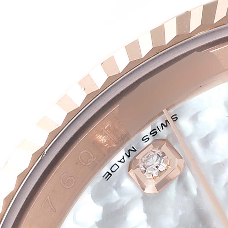 This close-up image shows the bezel, part of the dial, and a diamond hour marker of the Rolex President 116135 Men's Rose Gold Mother of Pearl Dial 116135 Men's Rose Gold Mother of Pearl Dial model watch.