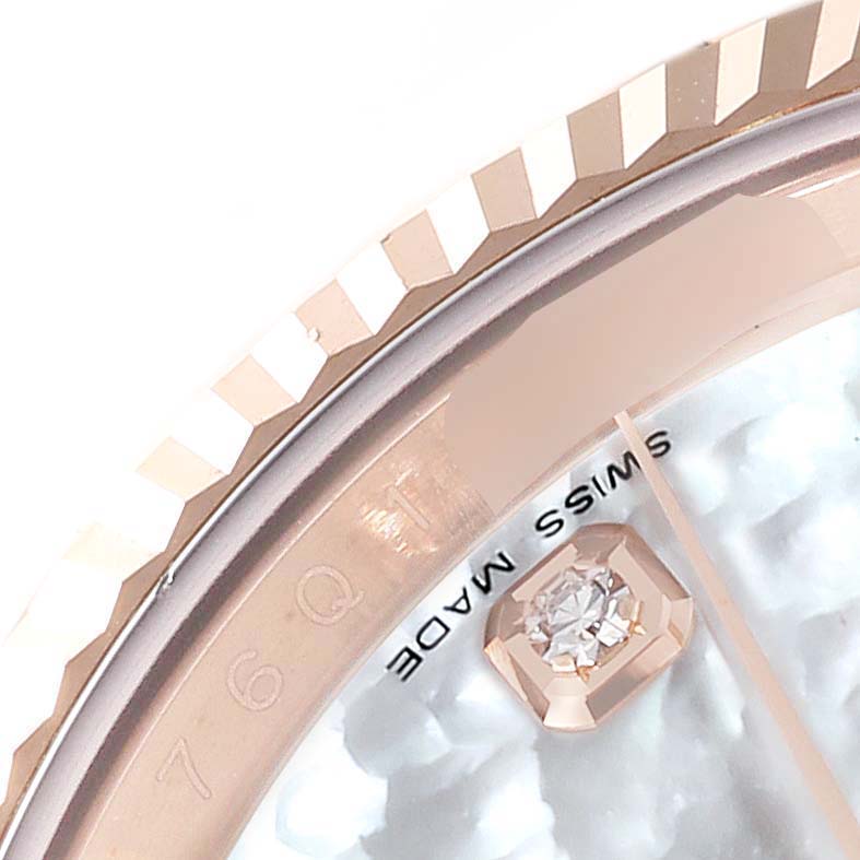 The image shows a close-up of the Rolex Datejust 116135 Men's Rose Gold Mother of Pearl Dial's bezel and part of its dial featuring a diamond marker.