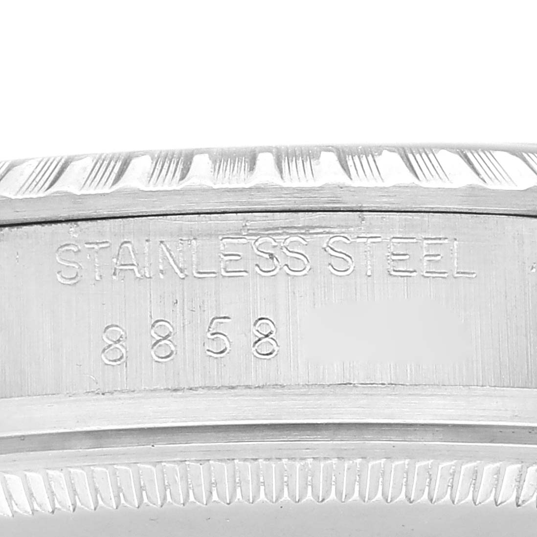 This close-up image of the Rolex Datejust 16030 Men's Stainless Steel White Dial 16030 Men's Stainless Steel White Dial watch shows the engraved text "STAINLESS STEEL" and numbers "8858" on the case.