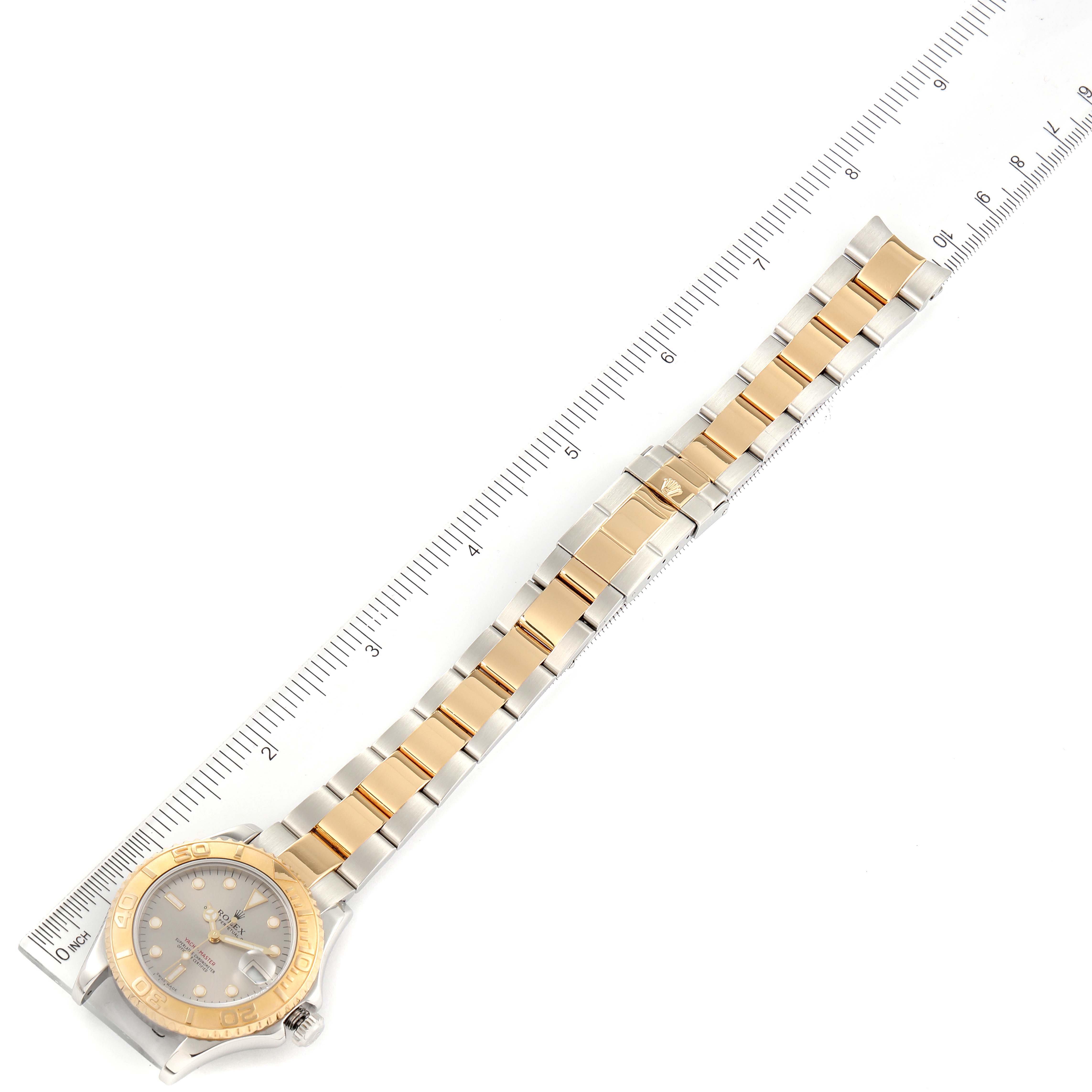 This image shows a top-down view of a Rolex Yacht-Master 168623 Men
s Steel and Gold (two tone) Grey Dial 168623 Men
s Steel and Gold (two tone) Grey Dial watch, displaying the face and two-tone bracelet alongside a ruler.