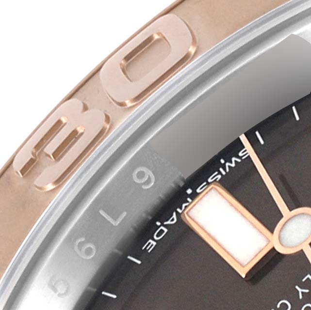 A close-up of the Rolex Yacht-Master 116621 Men's Steel and Gold (two tone) Brown Dial 116621 Men's Steel and Gold (two tone) Brown Dial watch shows part of the bezel, dial, and hands from a side angle.