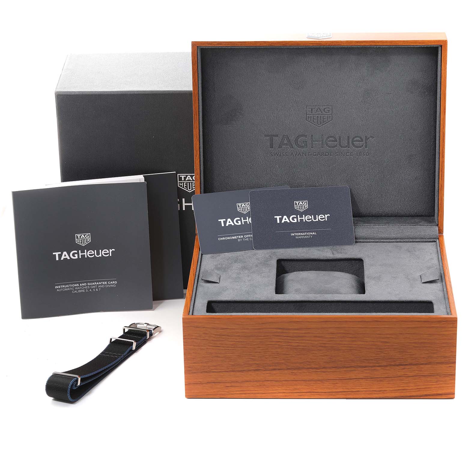 The image shows the packaging, manuals, warranty cards, and an extra strap for the Tag Heuer Autavia WBE5116.EB0173 Men's Stainless Steel Blue Dial WBE5116.EB0173 Men's Stainless Steel Blue Dial watch.