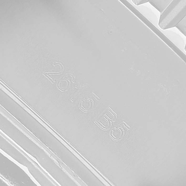 The image shows a close-up of raised text on a component, possibly part of the Breitling Superocean A17392 Men's Stainless Steel Blue Dial packaging or case.