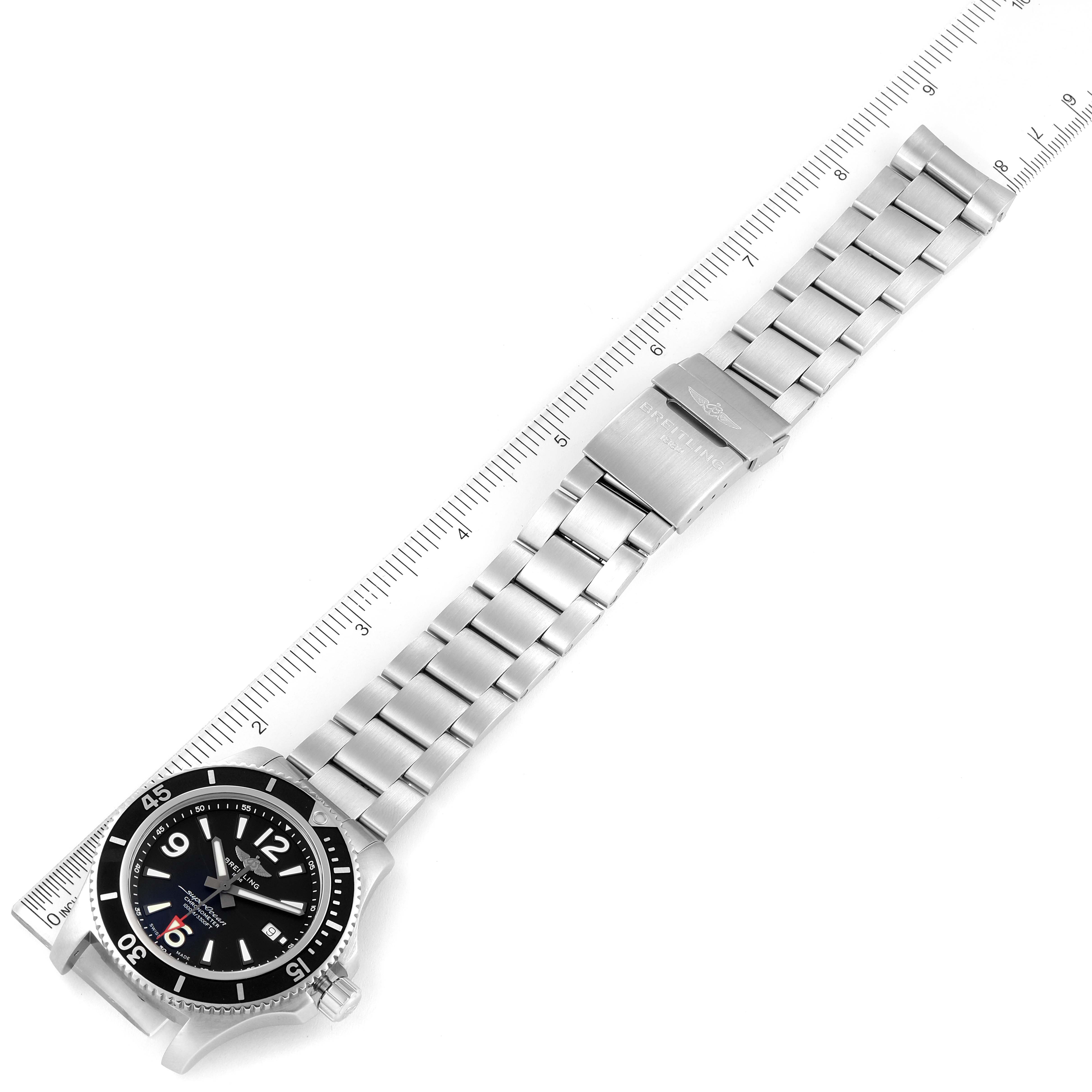 The image shows a top-down view of a Breitling Superocean A17367 Men's Stainless Steel Black Dial A17367 Men's Stainless Steel Black Dial watch with its entire stainless steel bracelet and clasp laid on a ruler.