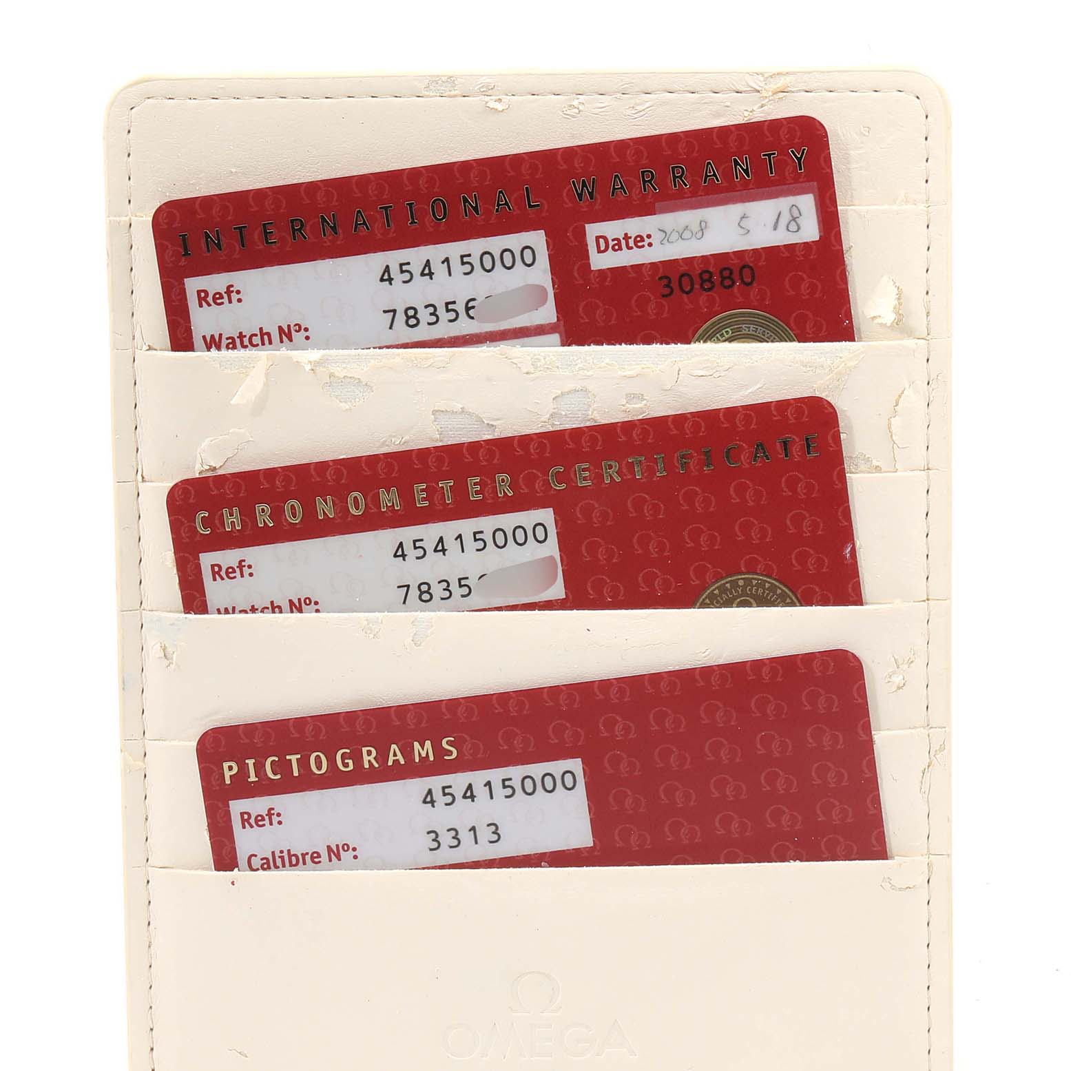 This image shows three red Omega De Ville 4541.50.00 Men's Stainless Steel Black Dial 4541.50.00 Men's Stainless Steel Black Dial cards in a white holder: an international warranty, chronometer certificate, and pictograms.