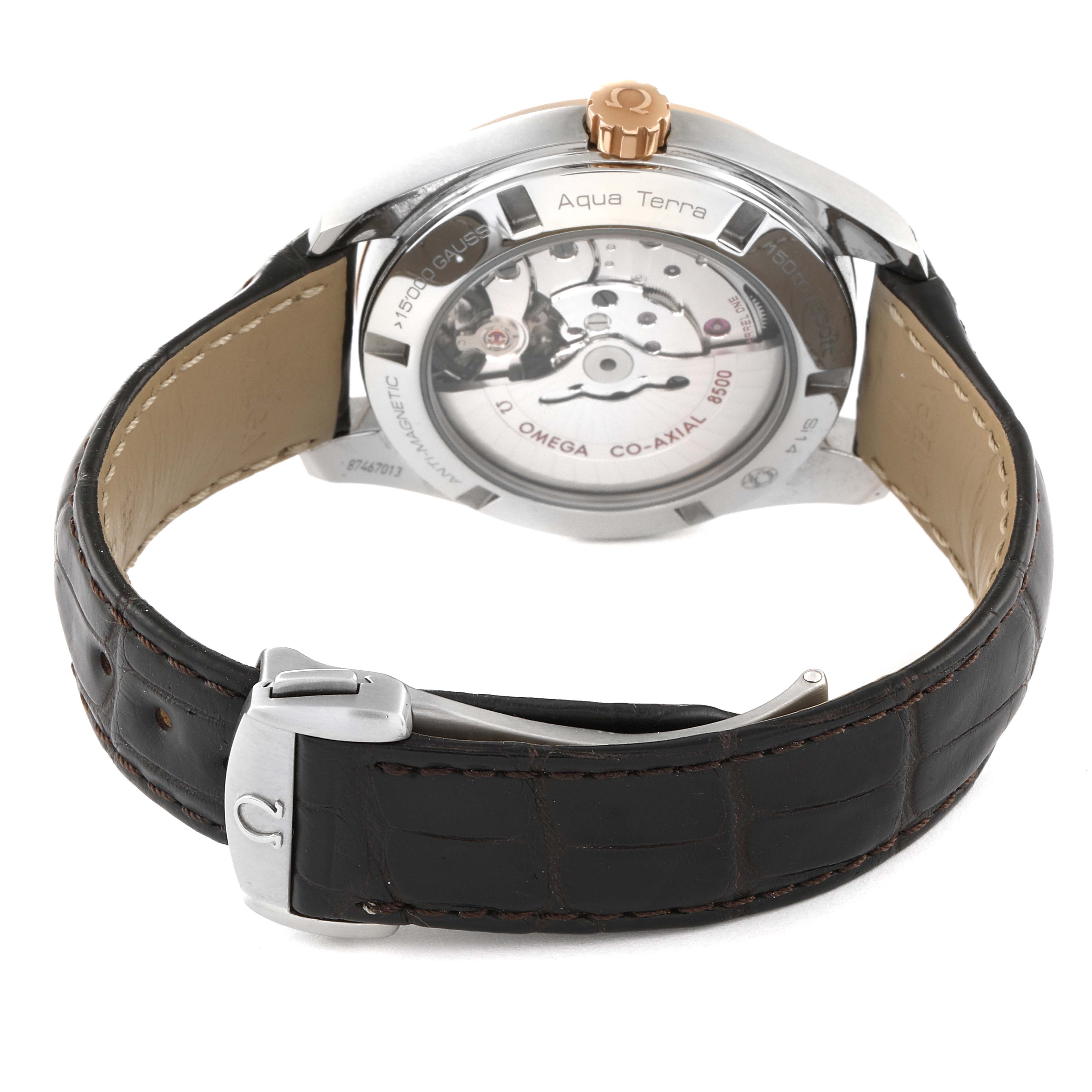 The image shows the back of an Omega Aqua Terra 231.23.42.21.02.001 Men's Steel and Gold (two tone) Silver Dial 231.23.42.21.02.001 Men's Steel and Gold (two tone) Silver Dial watch, highlighting its Co-Axial 8500 movement and leather strap with a clasp.