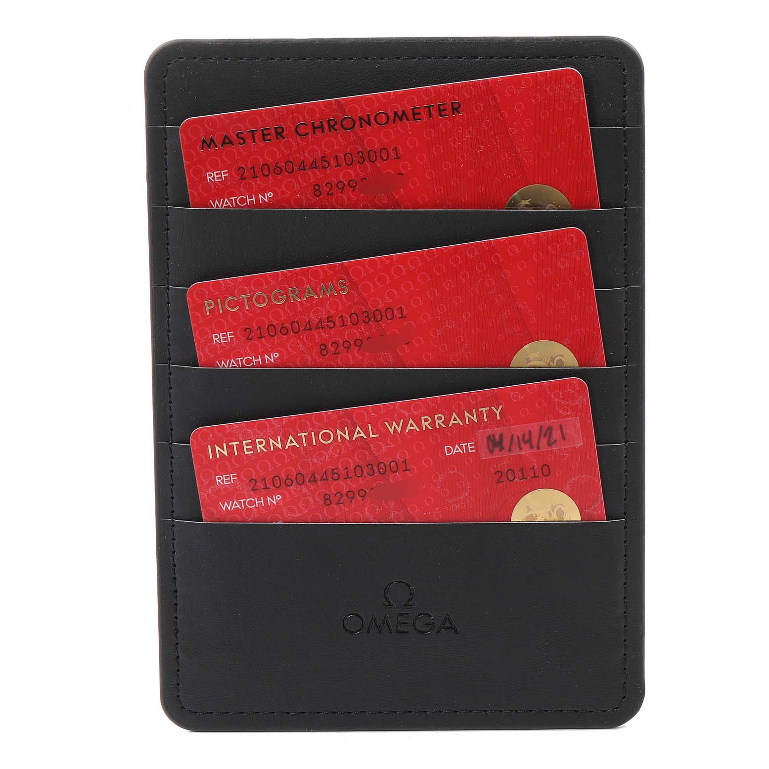 The image shows a black Omega cardholder containing three cards: Master Chronometer, Pictograms, and International Warranty for the Seamaster model.