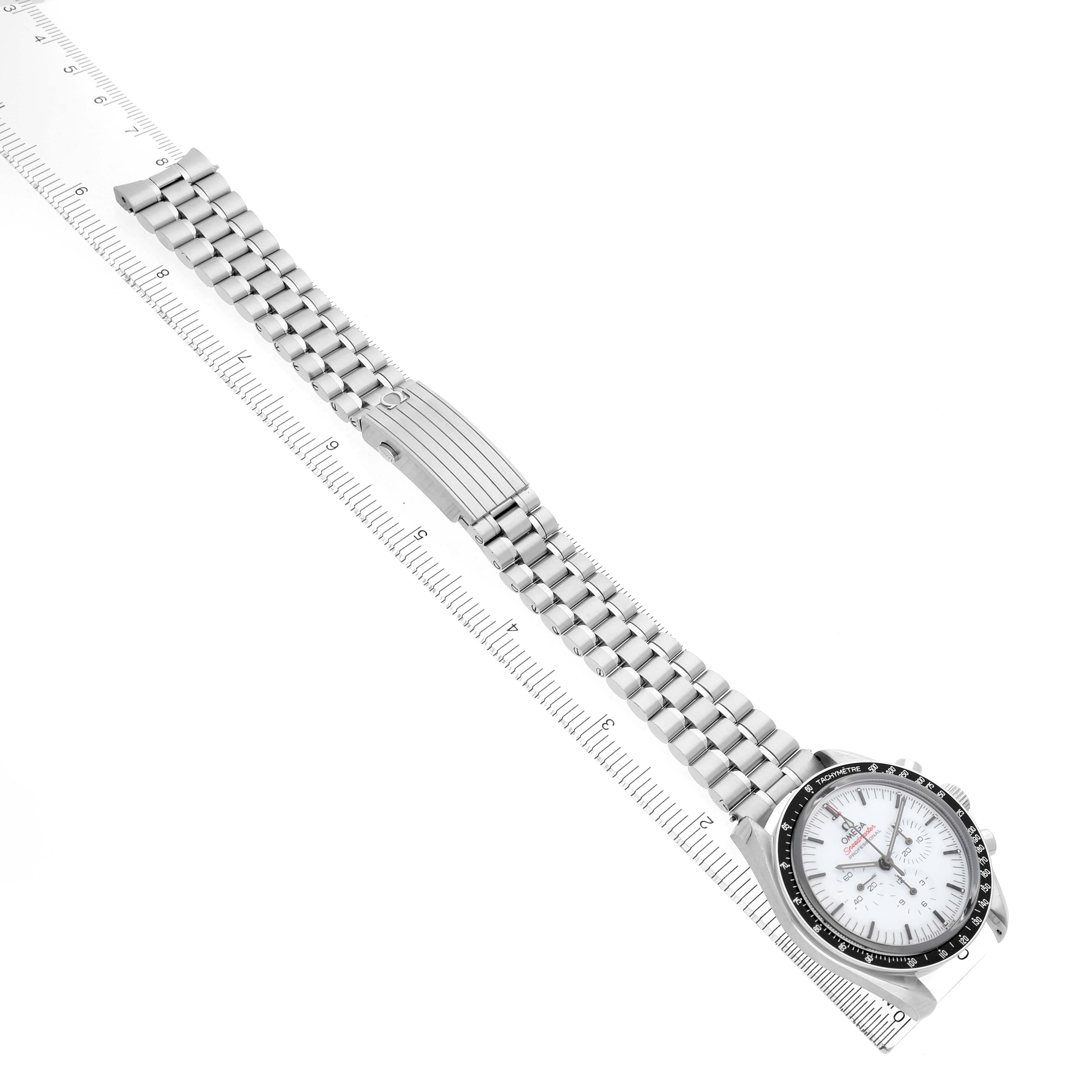 The Omega Speedmaster 310.30.42.50.04.001 Men's Stainless Steel White Dial watch is shown at a diagonal angle, featuring the face, bezel, bracelet, and clasp along a ruler.