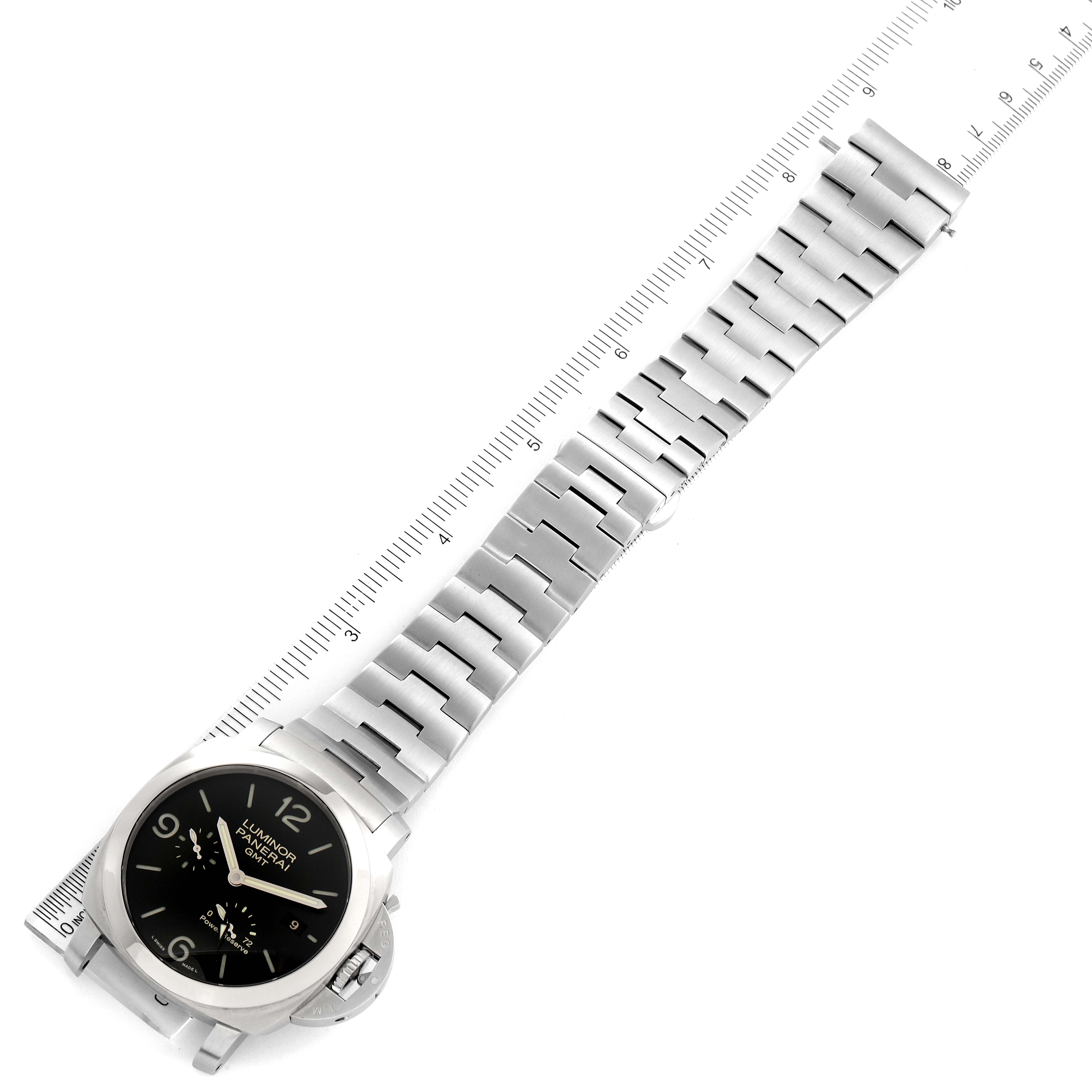 The image shows a top-down view of a Panerai Luminor PAM00347 Men
s Stainless Steel Black Dial PAM00347 Men
s Stainless Steel Black Dial watch with a stainless steel strap next to a ruler.