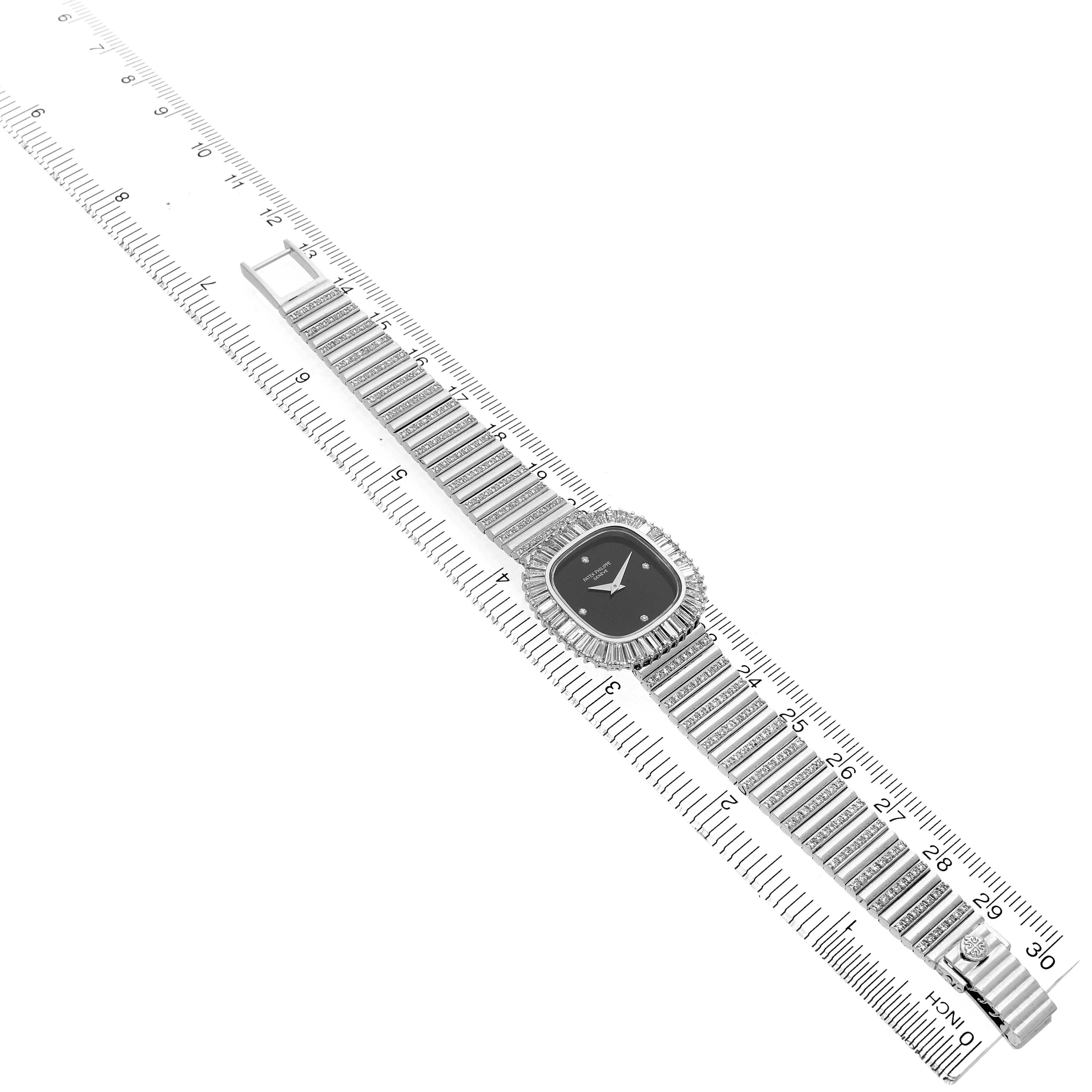 The Vintage Patek Philippe watch is shown at an oblique angle, displaying its full bracelet and diamond-encrusted bezel and case.