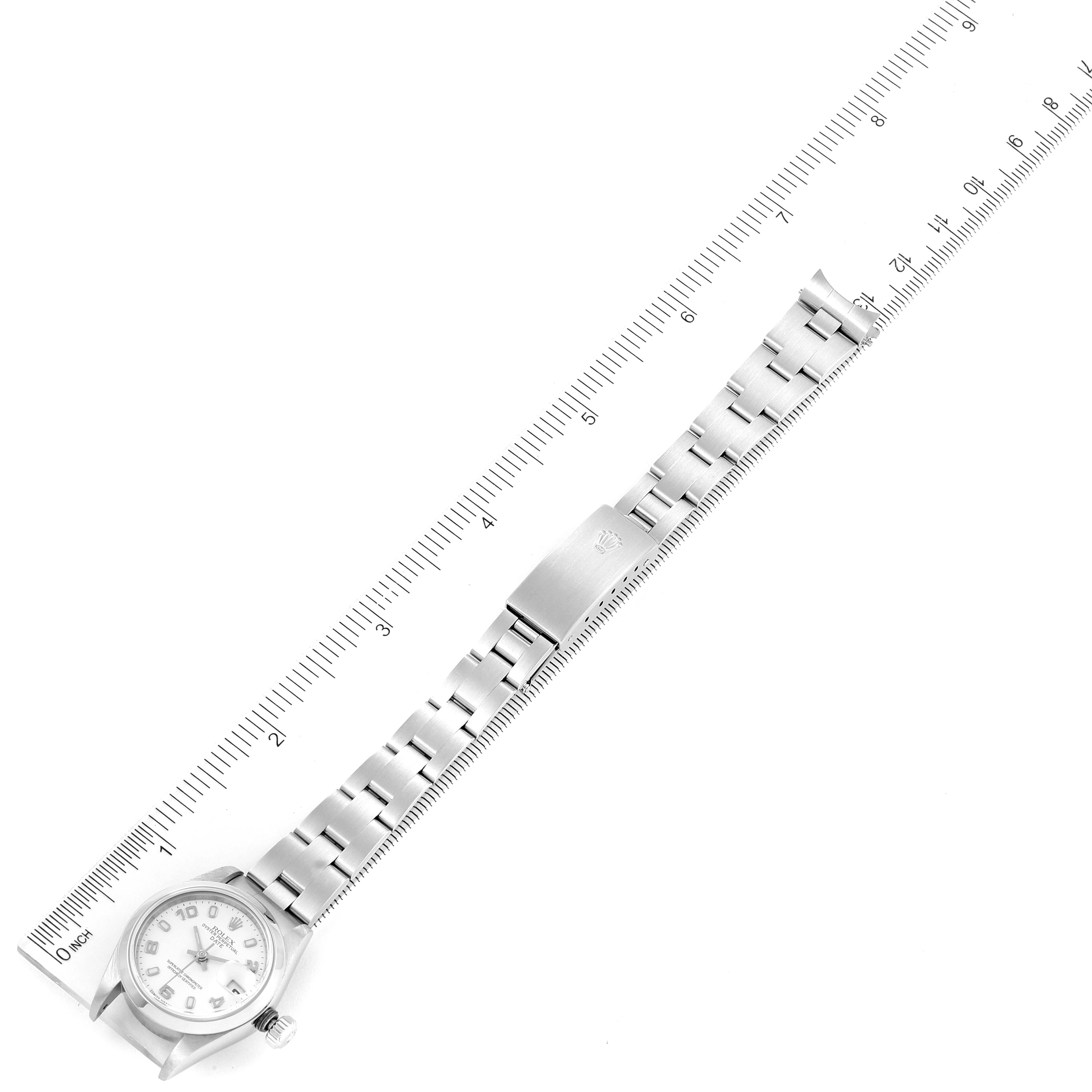 The Rolex Date 79160 Women's Stainless Steel White Dial 79160 Women's Stainless Steel White Dial model watch is shown from a top-down angle, displaying the full bracelet and clasp alongside a ruler for scale.
