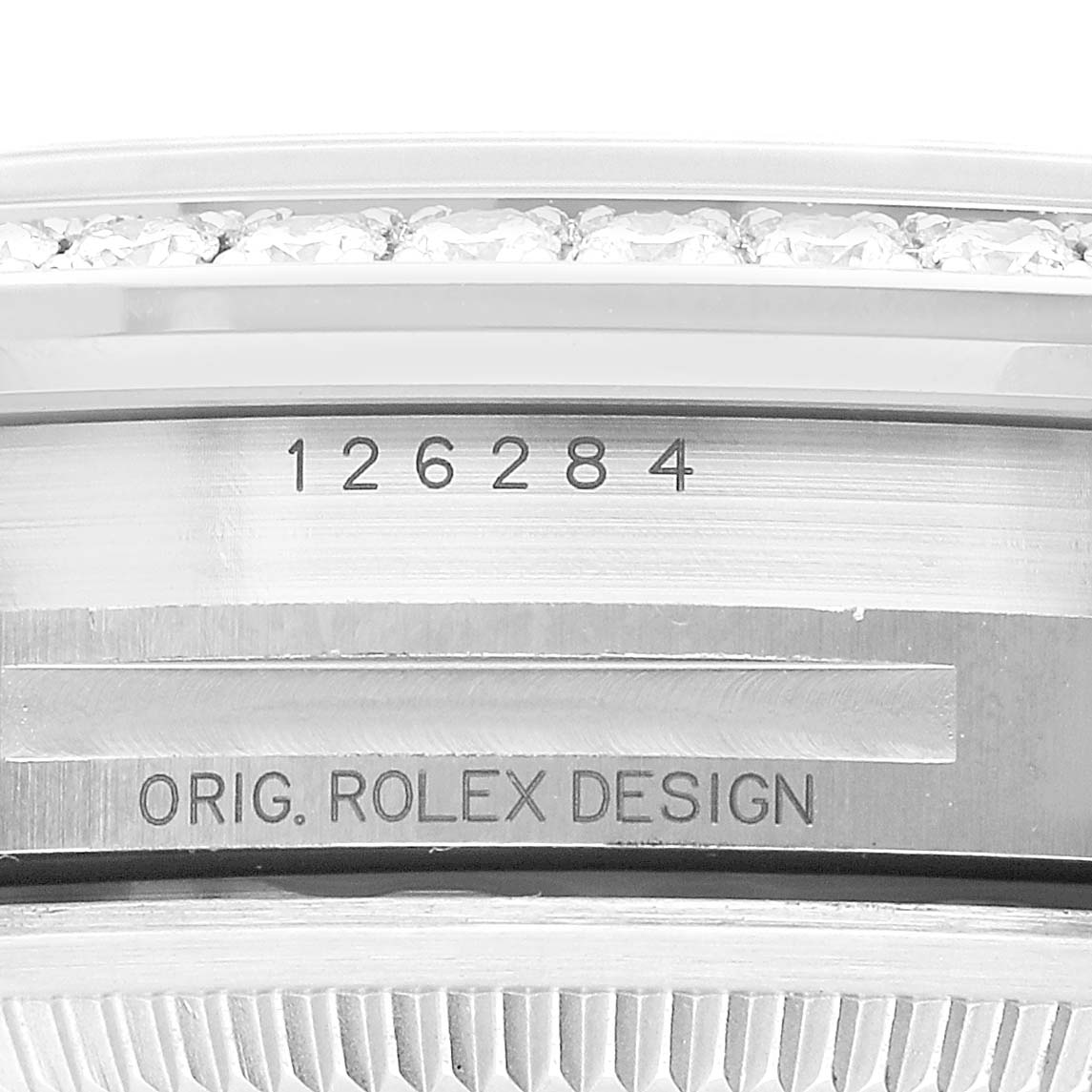 The image shows the side of a Rolex Datejust 126284 Men's Stainless Steel Blue Dial, focusing on the model number and "ORIG. ROLEX DESIGN" engraving beneath a diamond bezel.