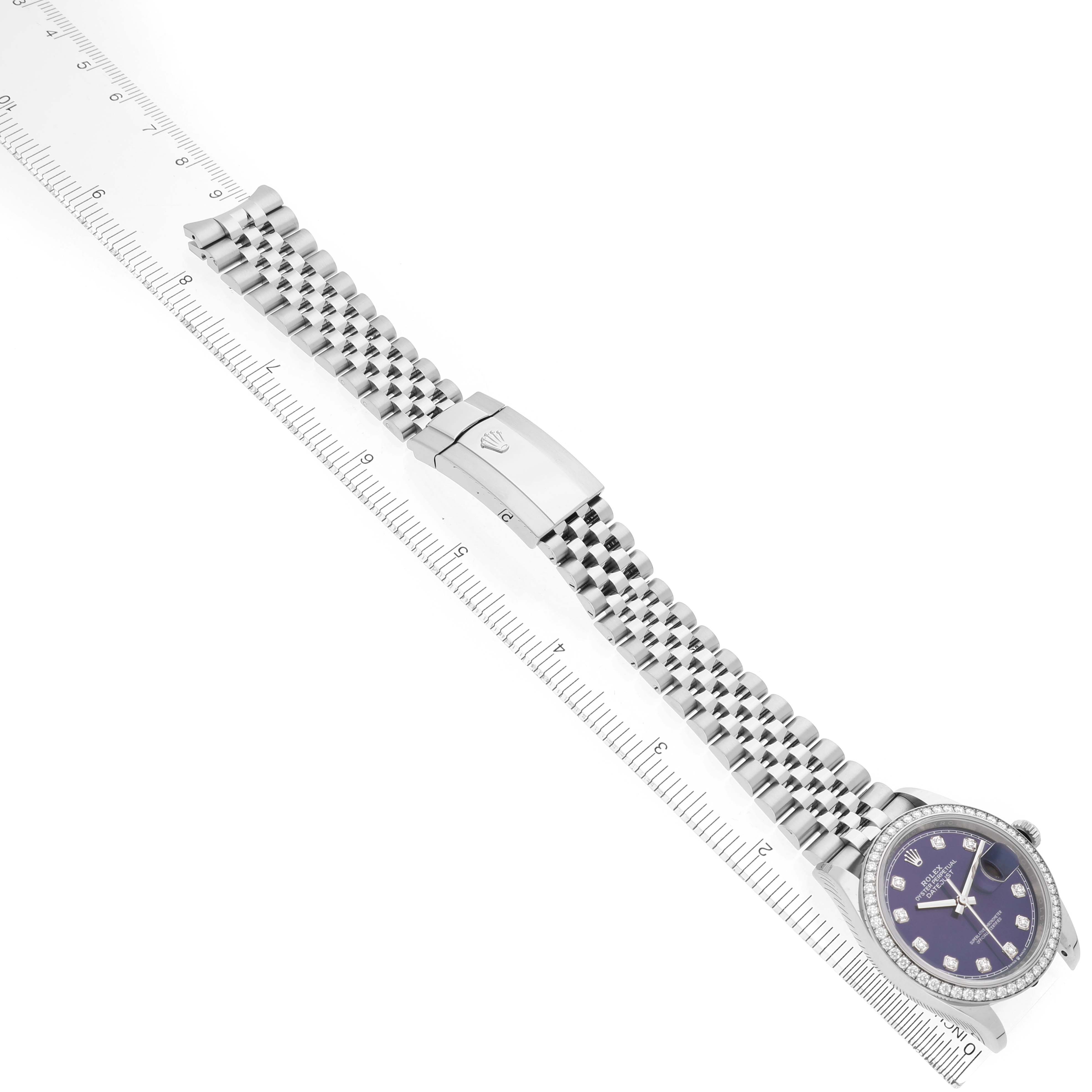 The image shows a Rolex Datejust 126284 Men's Stainless Steel Purple Dial watch laying flat, featuring its face, bezel, bracelet, and clasp, seen from an overhead angle.