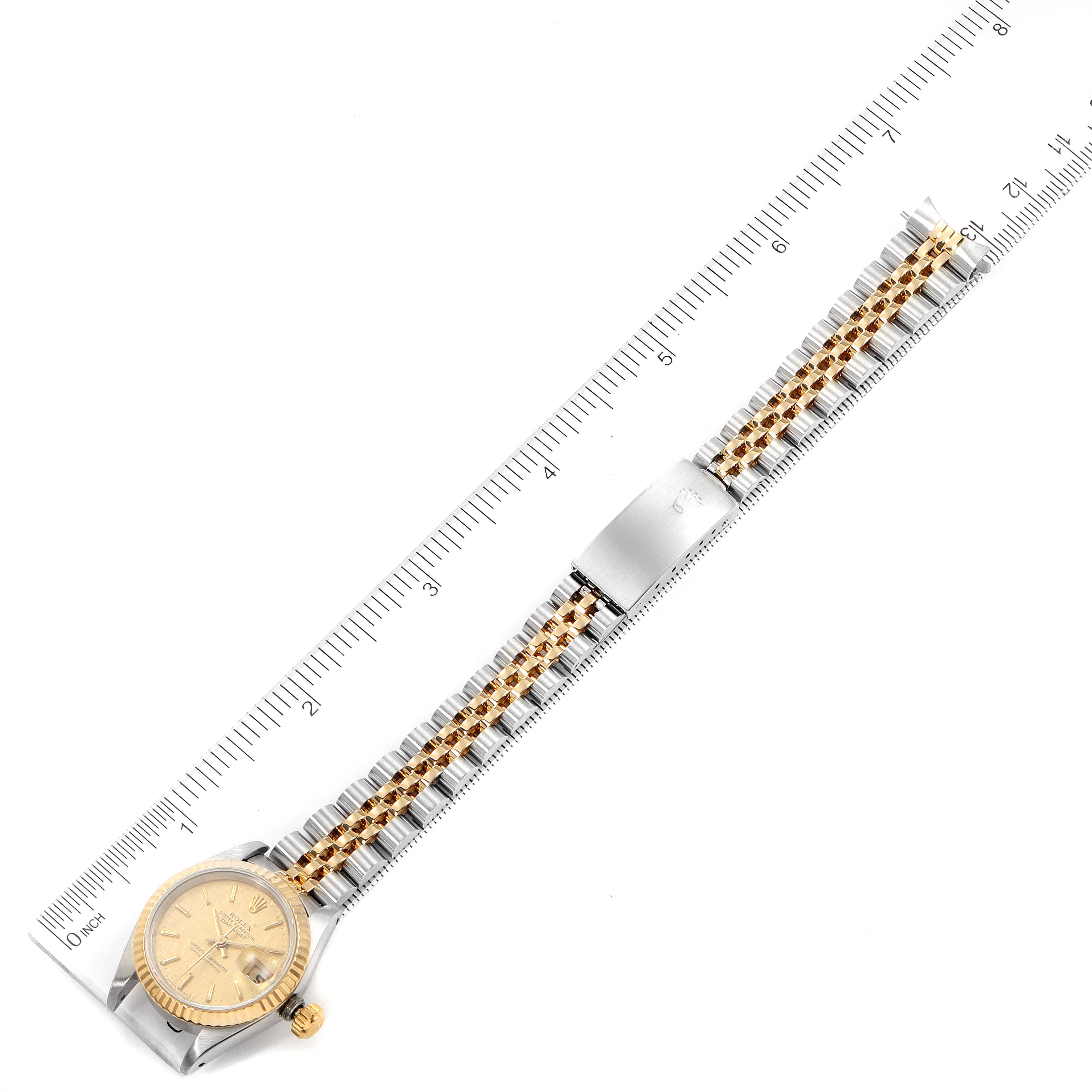The image shows a top-down view of a Rolex Datejust 69173 Women's Steel and Gold (two tone) Champagne Dial 69173 Women's Steel and Gold (two tone) Champagne Dial watch including its entire band, laid next to a ruler.