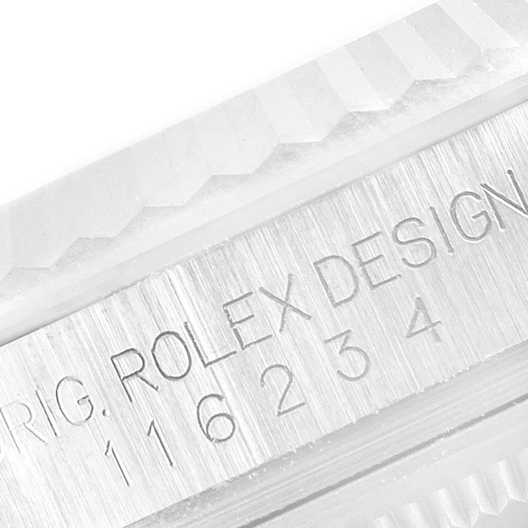 This close-up image of the Rolex Datejust 116234 Men's Stainless Steel Blue Dial 116234 Men's Stainless Steel Blue Dial watch focuses on the detailed engraving and fluted bezel.