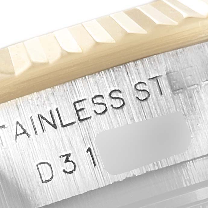 This image shows a close-up angle of the serial number and fluted bezel on a Rolex Datejust 179173 Women's Steel and Gold (two tone) Black Dial 179173 Women's Steel and Gold (two tone) Black Dial watch.