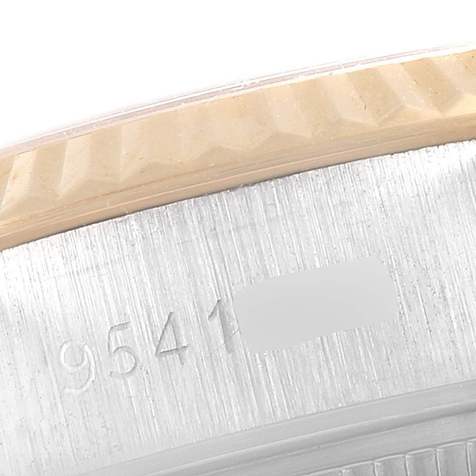 This image shows a close-up of the Datejust model by Rolex, focusing on the engraved serial number and bezel edge.