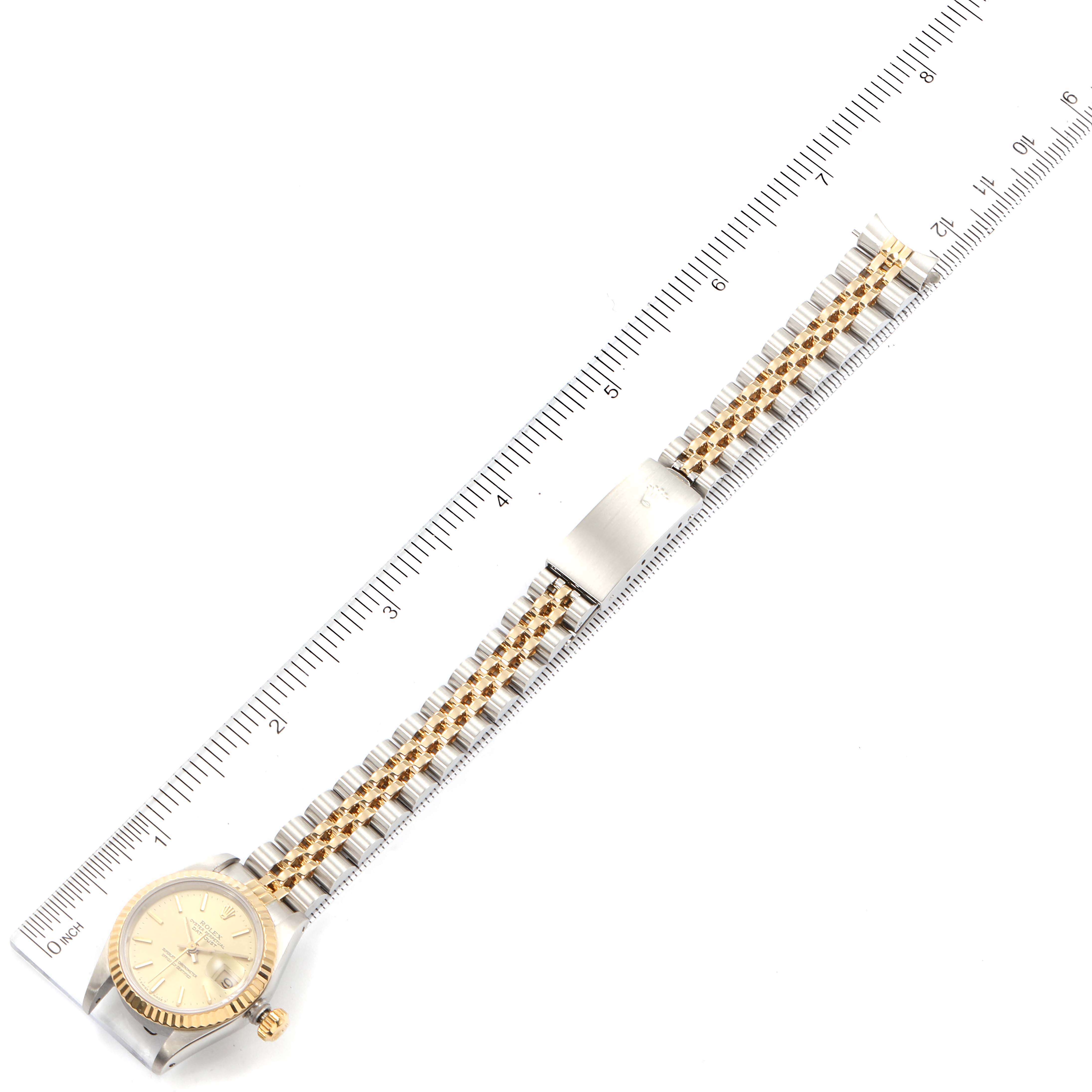 The Rolex Datejust 69173 Women's Steel and Gold (two tone) Champagne Dial 69173 Women's Steel and Gold (two tone) Champagne Dial watch is shown laid flat with the face, bracelet, and clasp visible, alongside a ruler for scale.