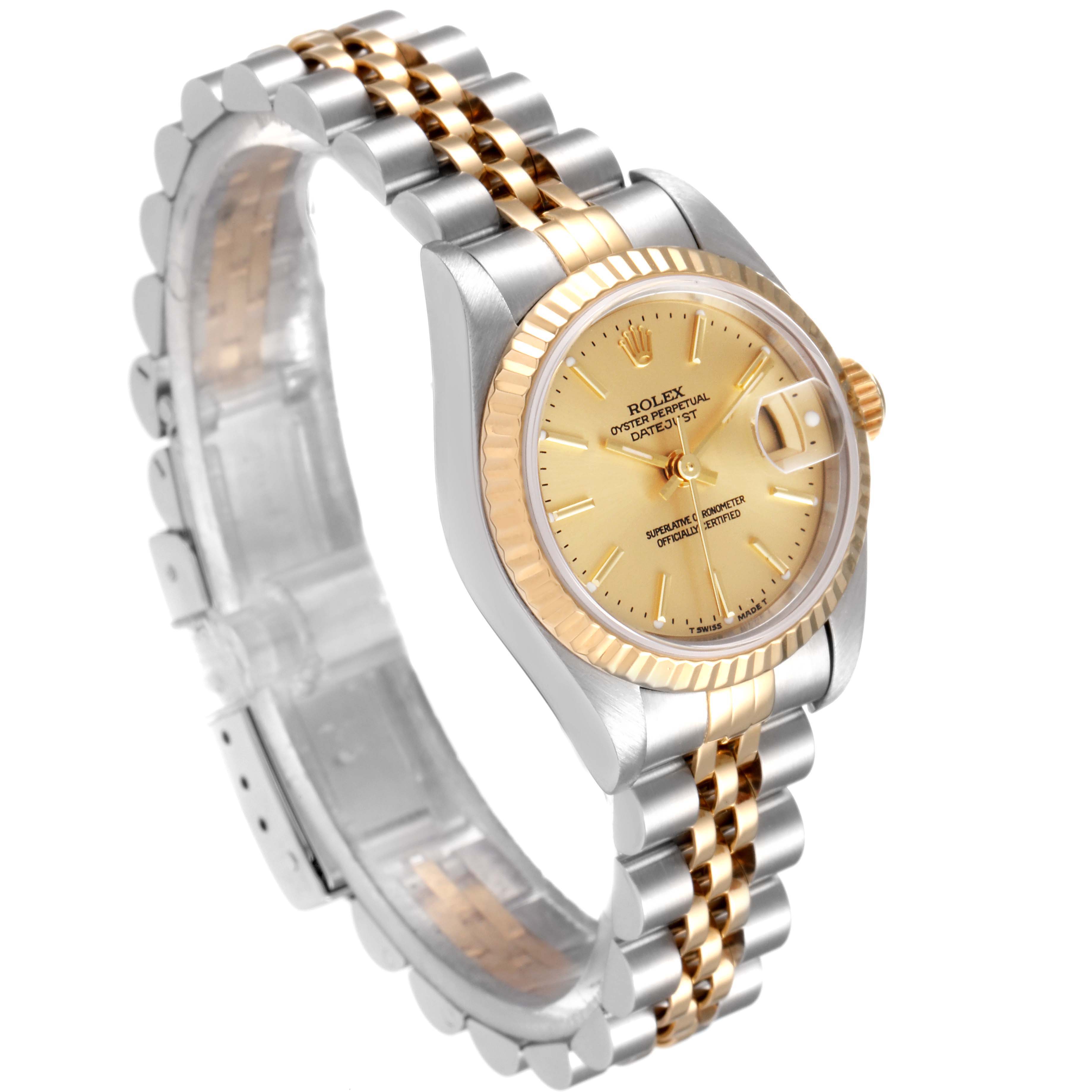 This Rolex Datejust 79173 Women's Steel and Gold (two tone) Champagne Dial 79173 Women's Steel and Gold (two tone) Champagne Dial watch is shown from a three-quarter angle, highlighting its gold dial, two-tone bracelet, fluted bezel, and date magnifier.