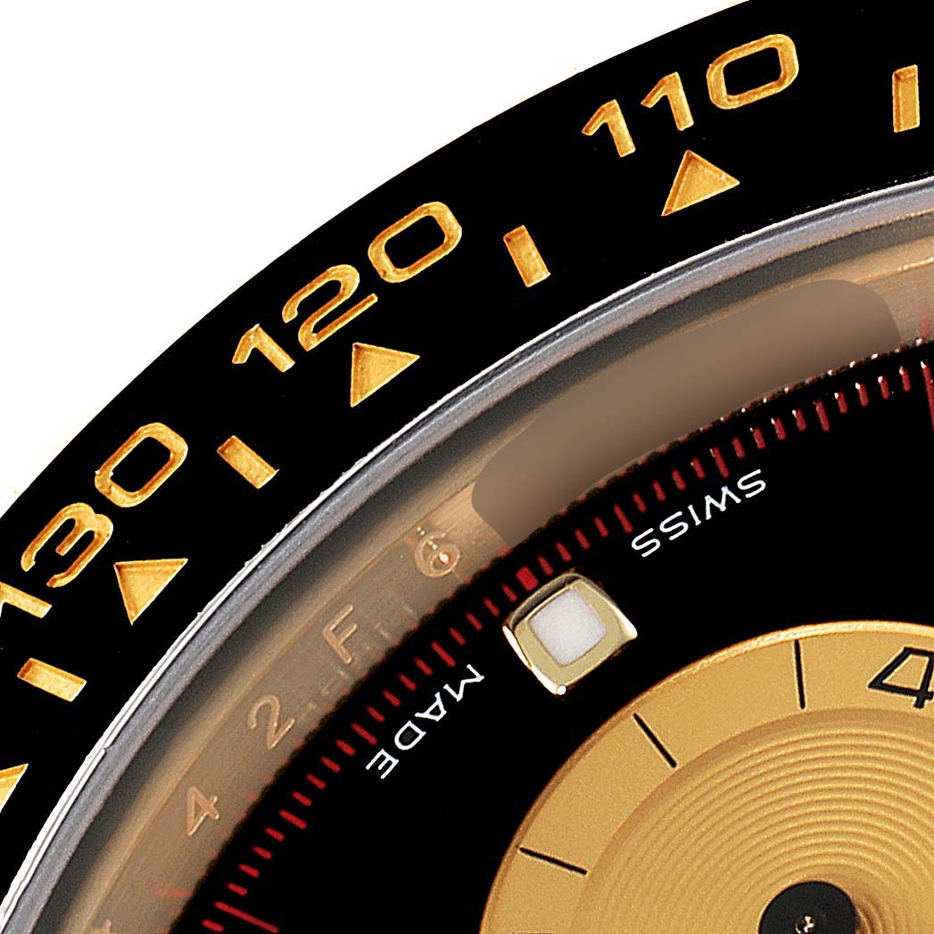 This close-up of the Rolex Daytona 116518 Men
s Yellow Gold Black Dial 116518 Men
s Yellow Gold Black Dial watch shows part of the bezel and dial, including the "Swiss Made" text and the tachymeter scale.