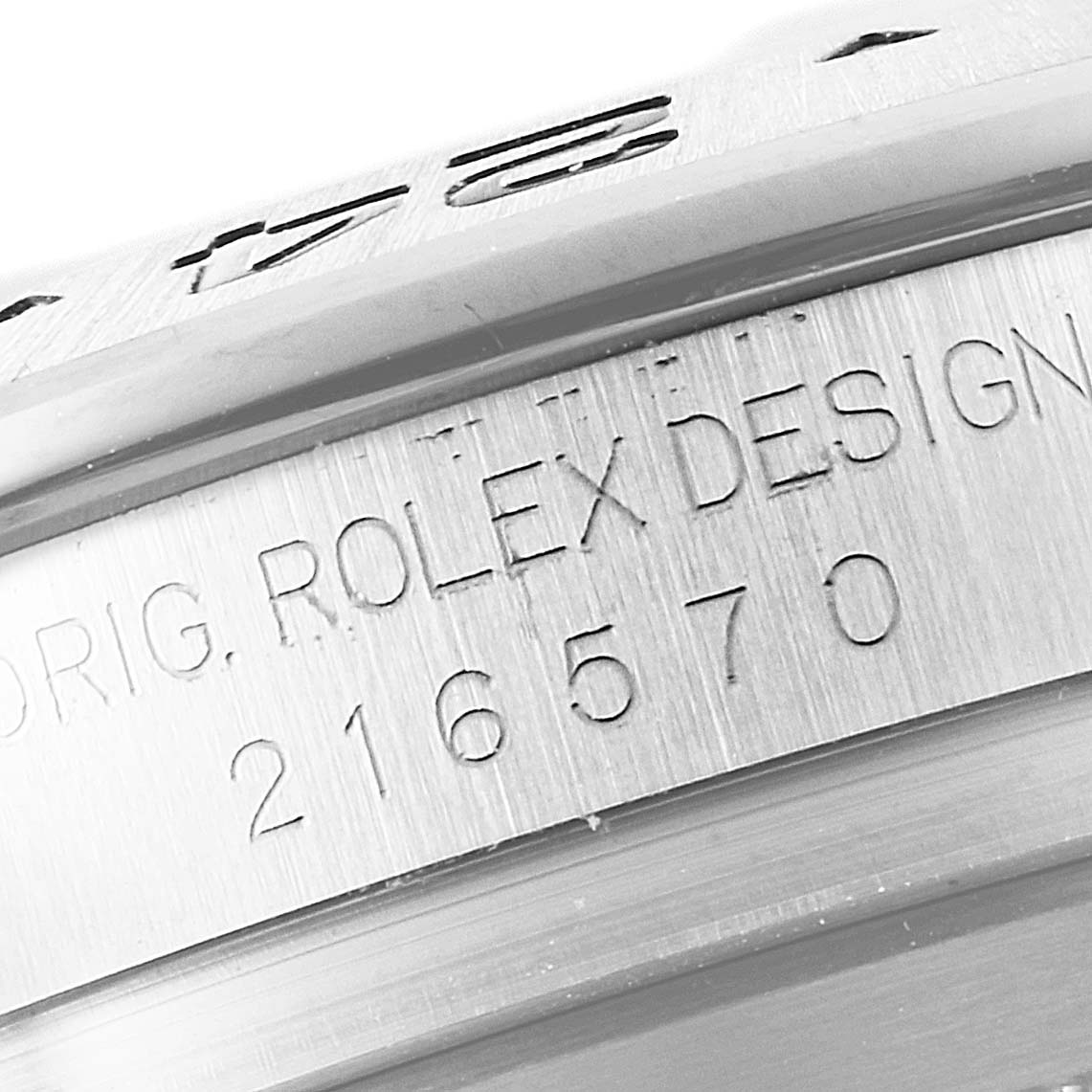 The image shows a close-up of the engraved casing of a Rolex Explorer 216570 Men
s Stainless Steel White Dial 216570 Men
s Stainless Steel White Dial model, highlighting part of the serial number and "ROLEX DESIGN."