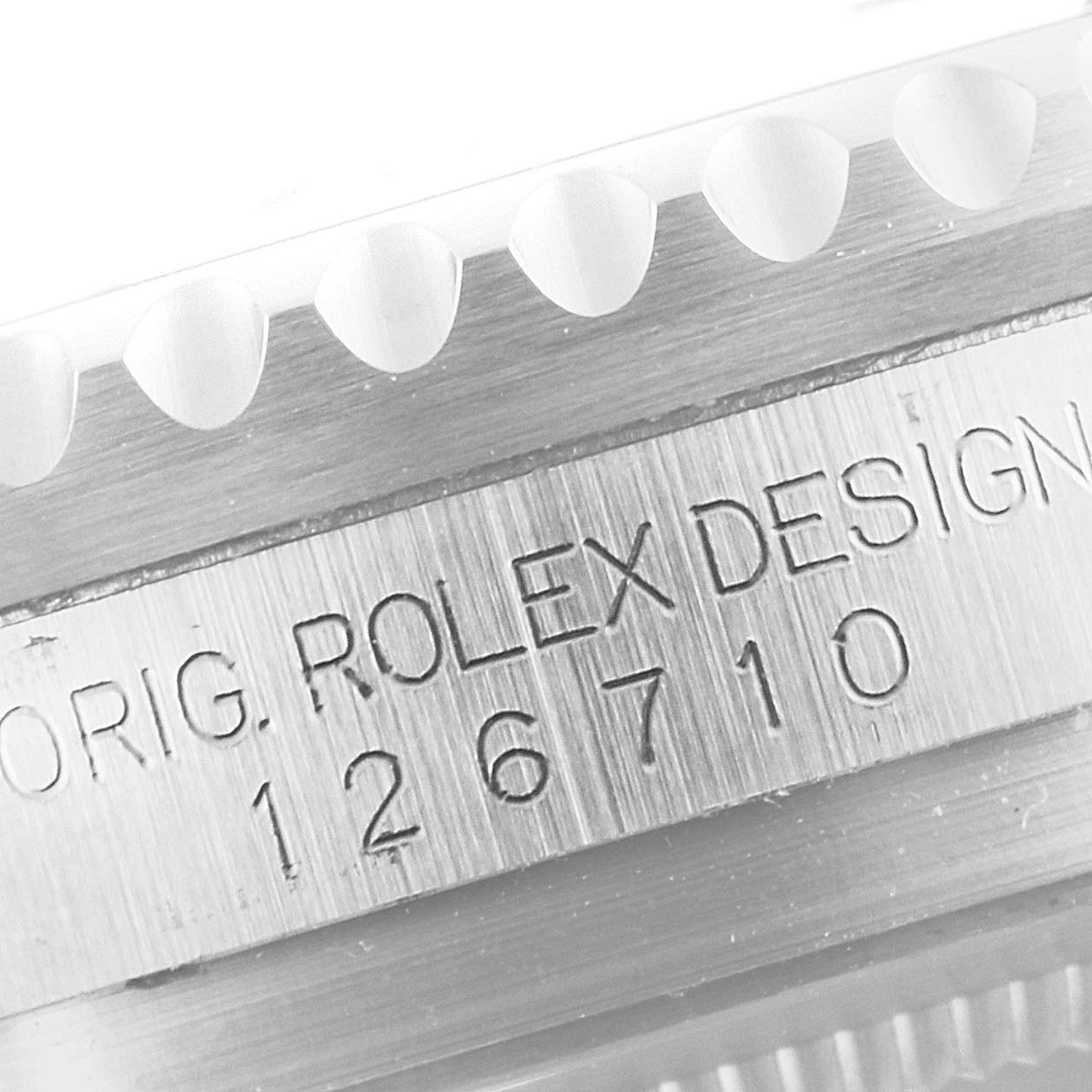 This image shows a close-up of the side of a Rolex GMT-Master 126710 Men
s Stainless Steel Black Dial 126710 Men
s Stainless Steel Black Dial watch (Model 126710), featuring its engraved serial number and part of the bezel.