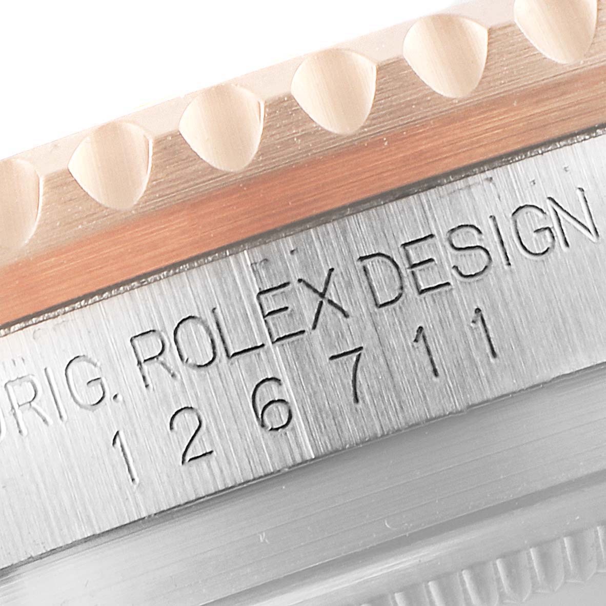 The image shows a close-up of the case side and bezel of a Rolex GMT-Master 126711 Men's Steel and Gold (two tone) Black Dial 126711 Men's Steel and Gold (two tone) Black Dial, displaying the engraving 'ROLEX DESIGN' and the model number.