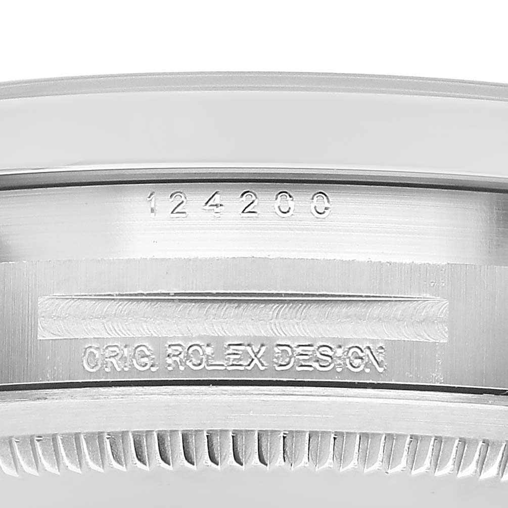 The image shows a close-up side view of the Rolex Oyster Perpetual 124200 Men's Stainless Steel Silver Dial watch, highlighting the bezel and etching.