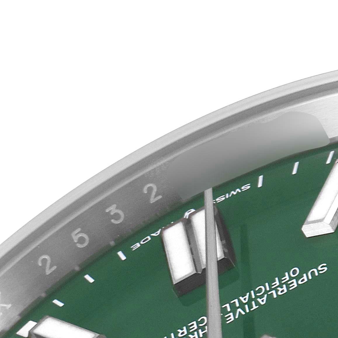 The image shows a close-up of the top right section of a Rolex Oyster Perpetual 124300 Men
s Stainless Steel Green Dial 124300 Men
s Stainless Steel Green Dial watch, highlighting the hours scale and part of the dial.