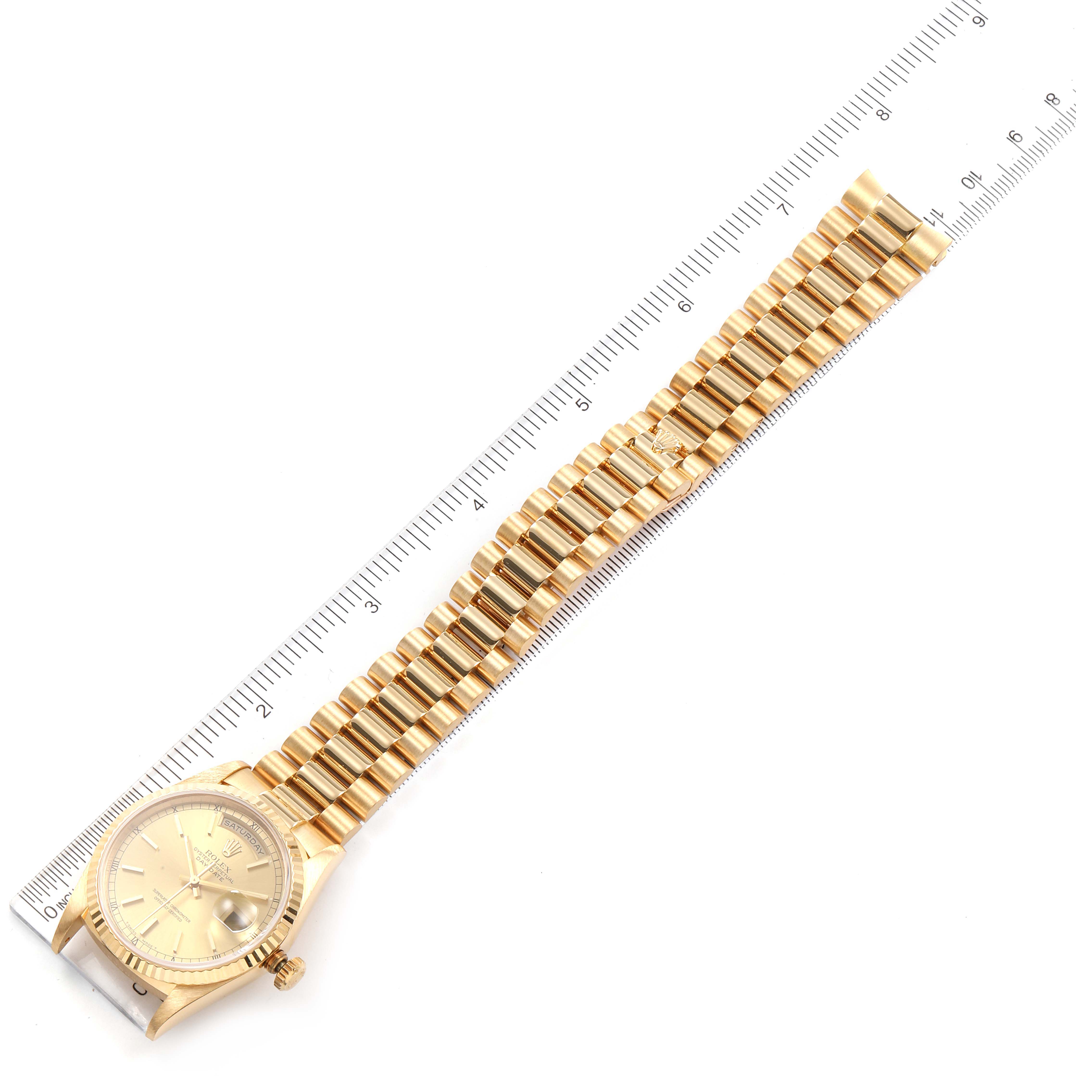The image shows the Rolex President 18238 Men
s Yellow Gold Champagne Dial 18238 Men
s Yellow Gold Champagne Dial model watch laid flat with its bracelet fully extended, alongside a measuring ruler.