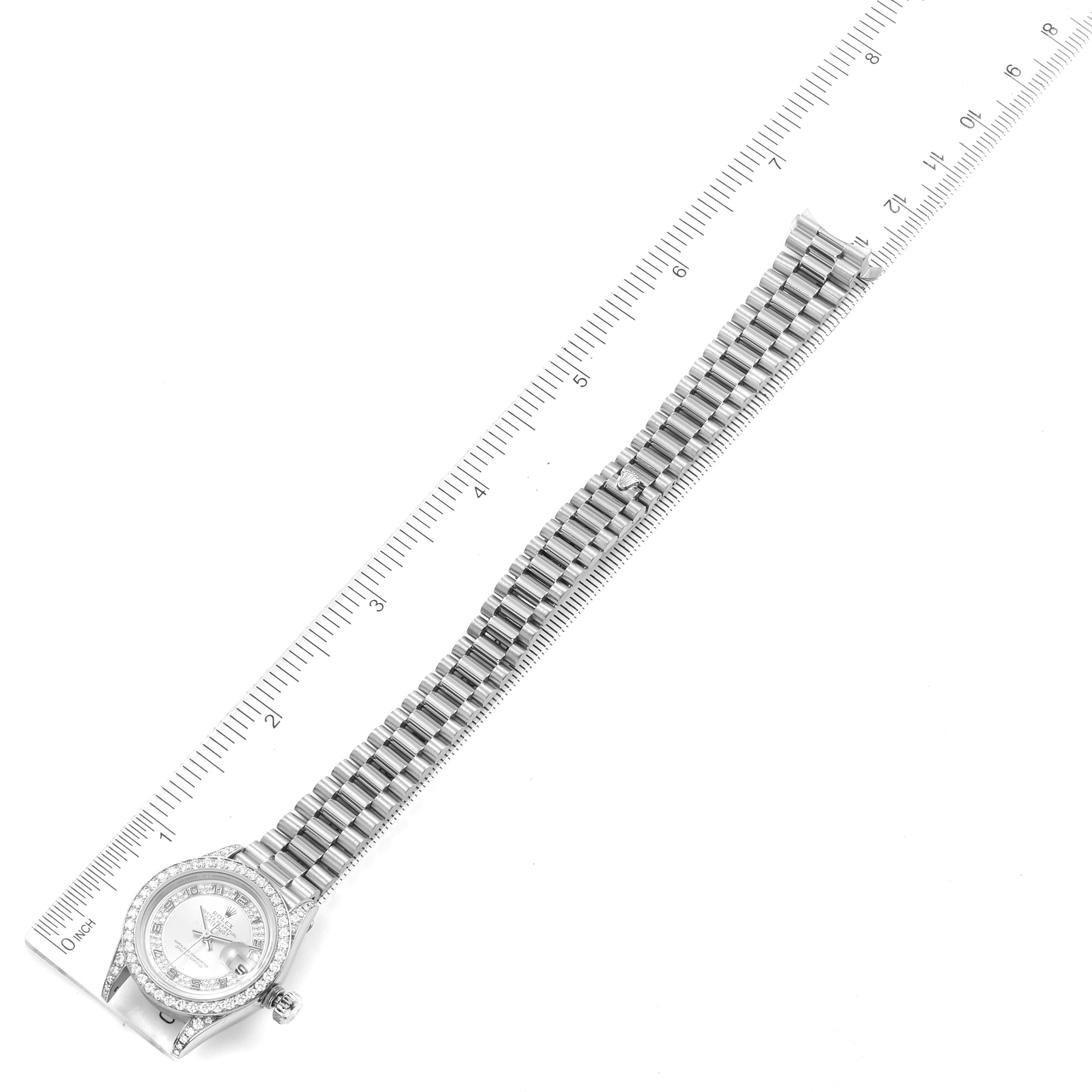 The image shows a top-down view of a Rolex President 69159 Women's White Gold Silver Dial 69159 Women's White Gold Silver Dial watch, including the bracelet and face, alongside a ruler for scale.