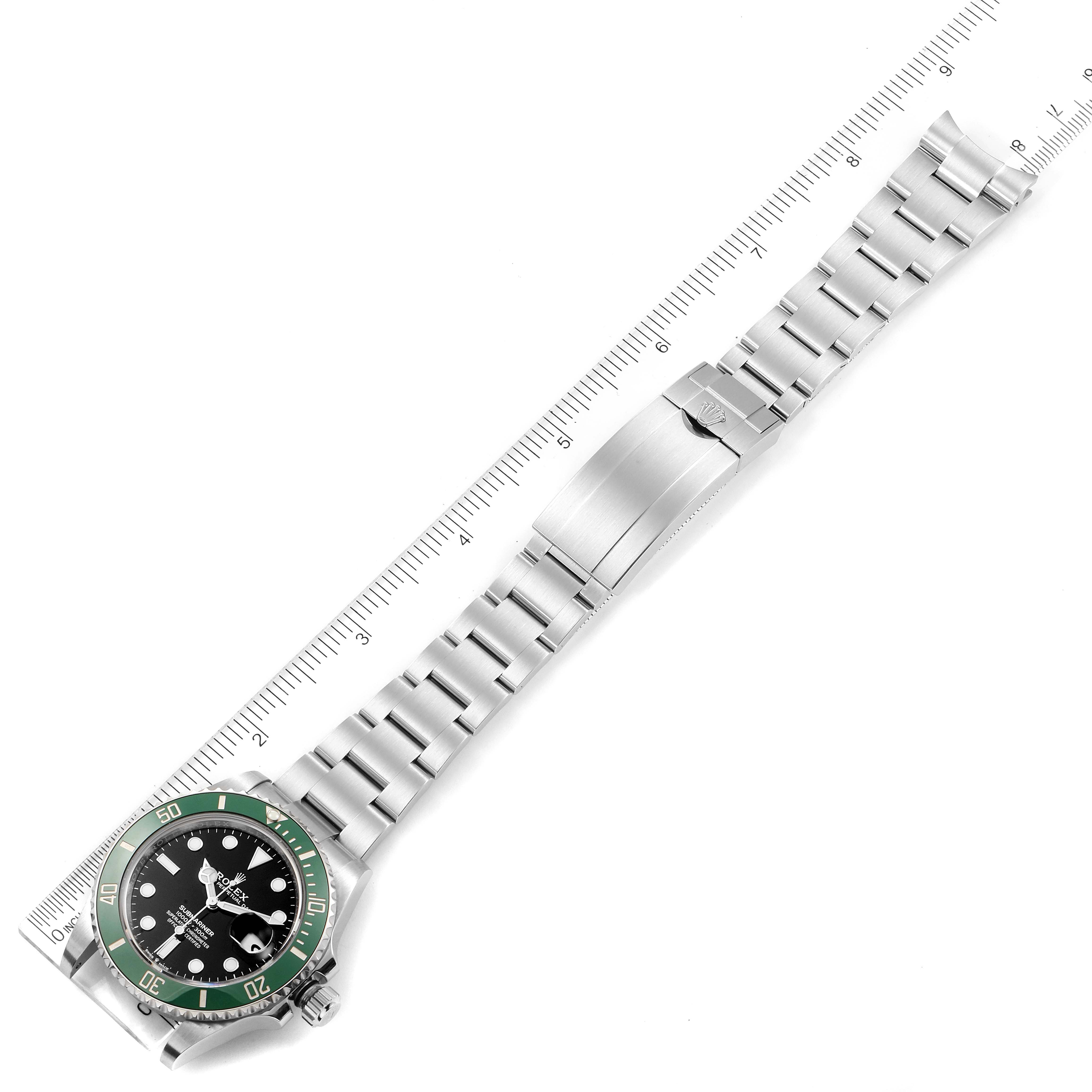 The image shows a top-down view of a Rolex Submariner 126610LV Men's Stainless Steel Black Dial 126610LV Men's Stainless Steel Black Dial watch with its stainless steel bracelet laid out flat alongside a ruler.