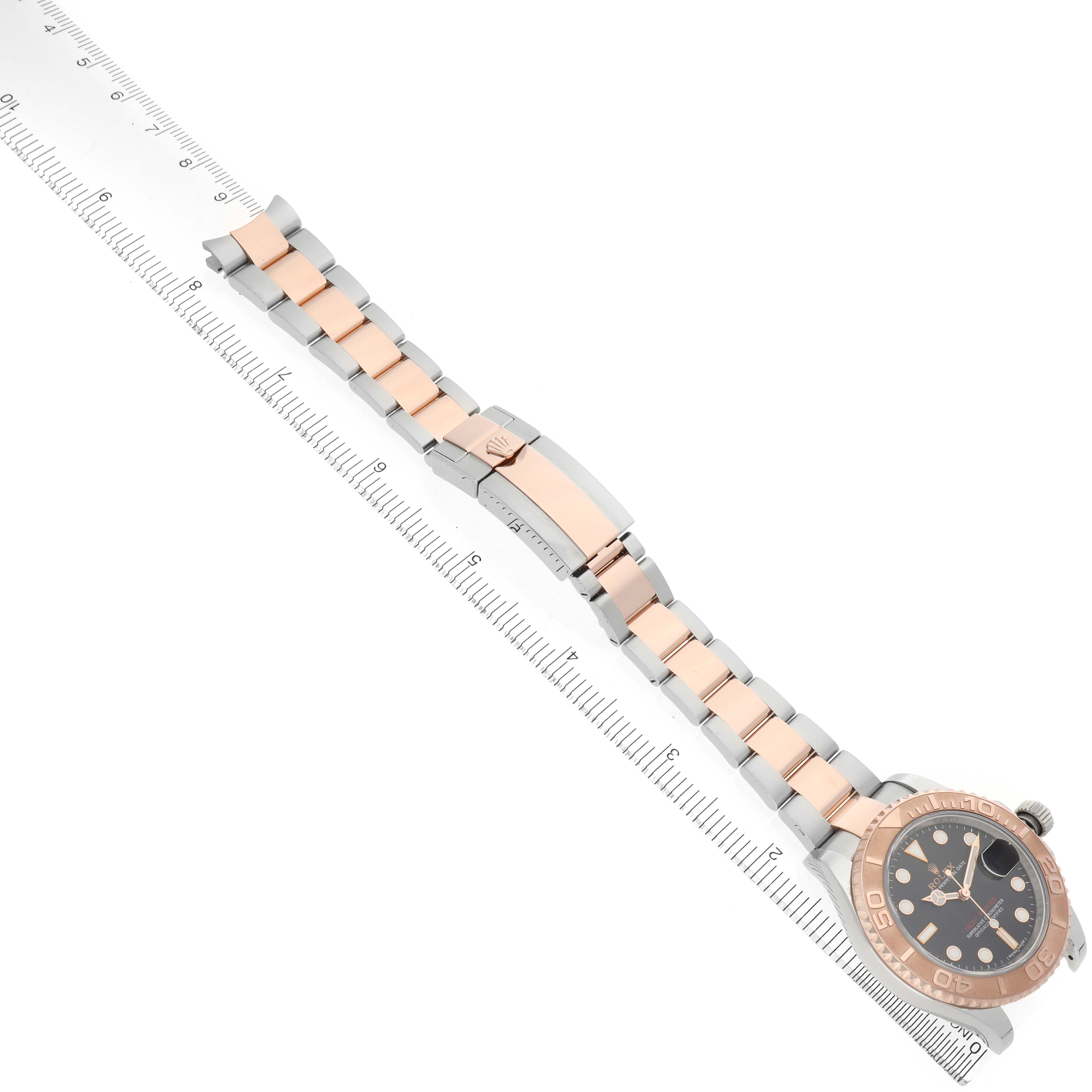 The Rolex Yacht-Master 116621 Men's Steel and Gold (two tone) Black Dial watch is displayed diagonally showing the full bracelet, bezel, and dial, alongside a ruler for scale.