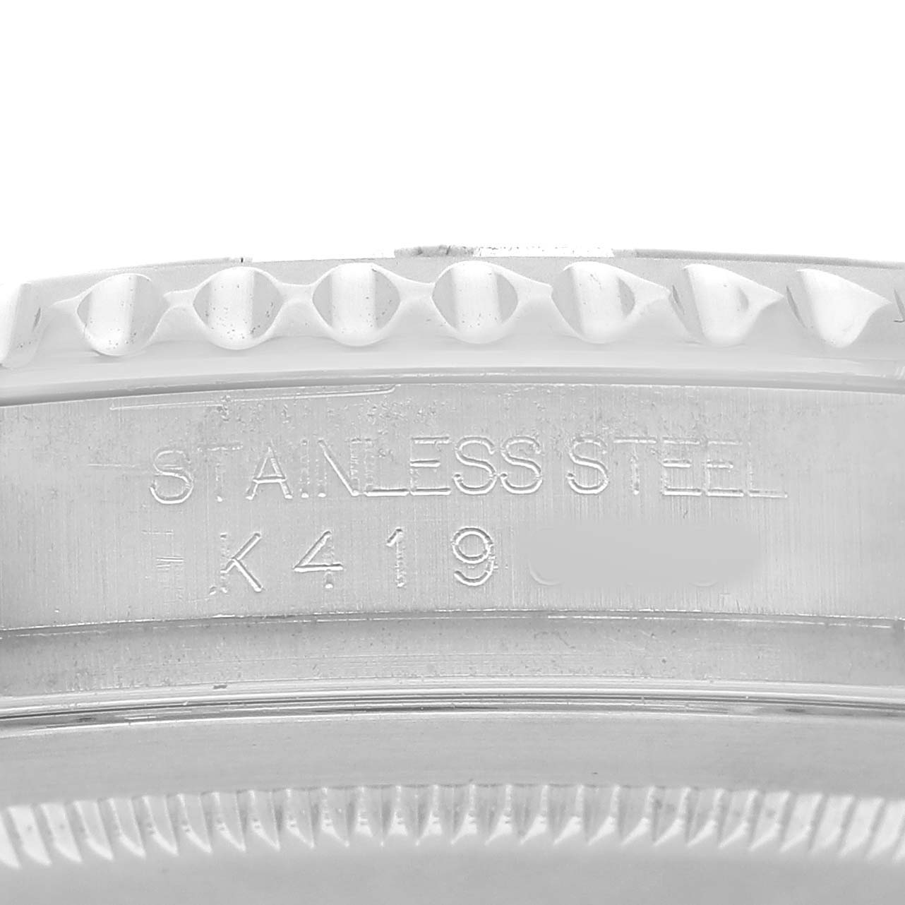 The image shows a close-up of the Yacht-Master by Rolex, focusing on the side with "STAINLESS STEEL" and a serial number engraving.