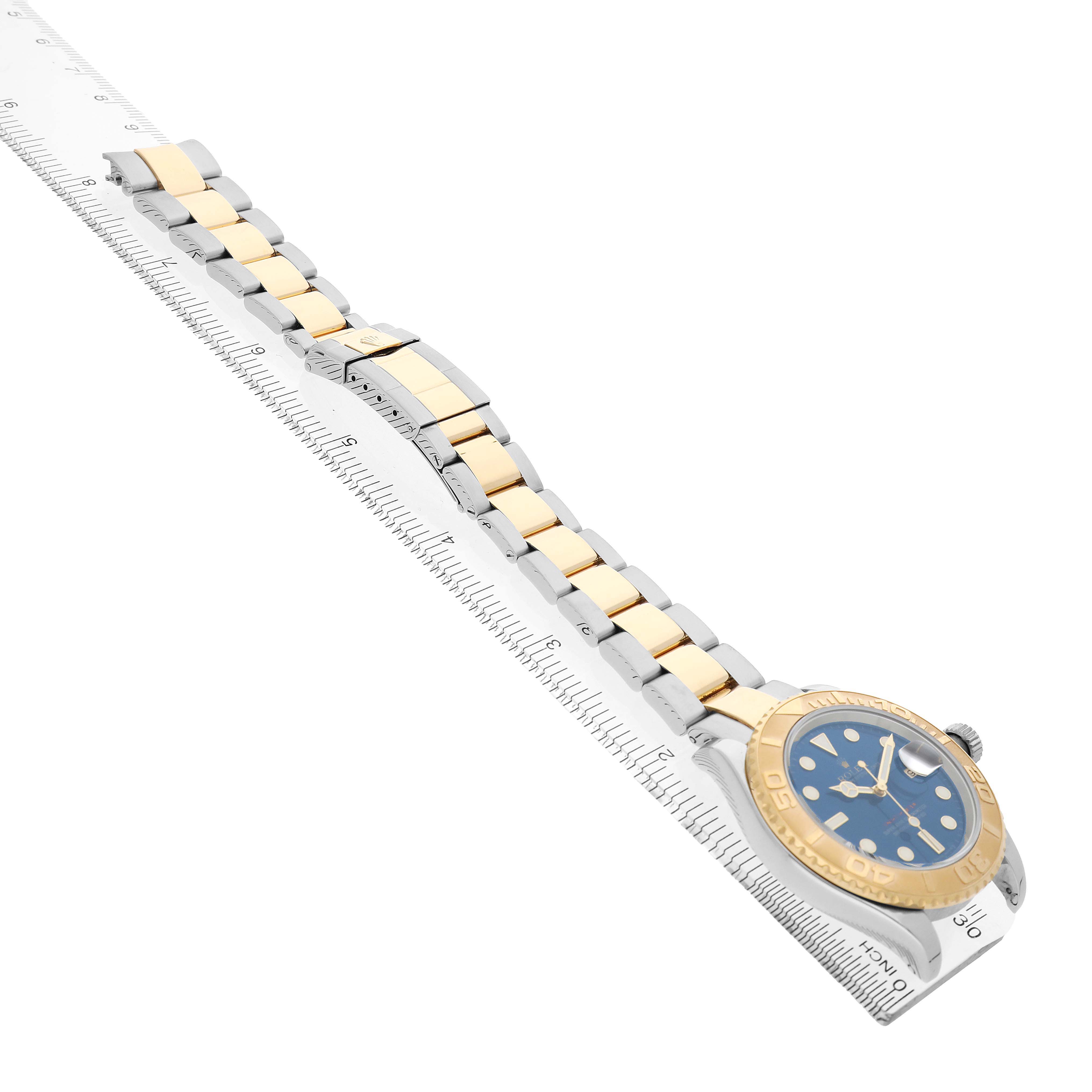 The Rolex Yacht-Master 16623 Men's Steel and Gold (two tone) Blue Dial watch is shown at a diagonal angle, displaying the bracelet, clasp, and face.