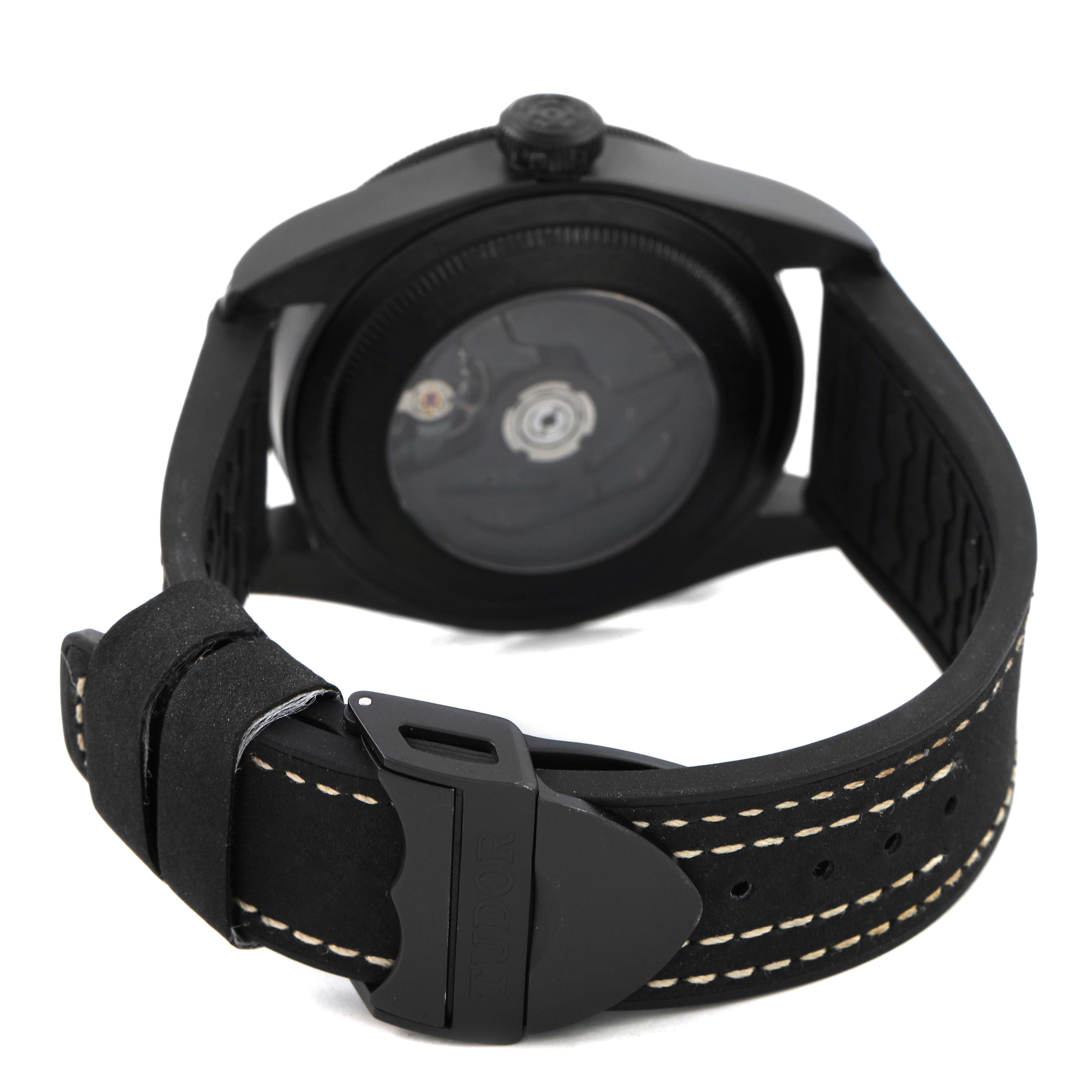 The image shows the Tudor Heritage Black Bay 79210 Men's Ceramic Black Dial watch from the rear angle, highlighting the strap buckle and case back.