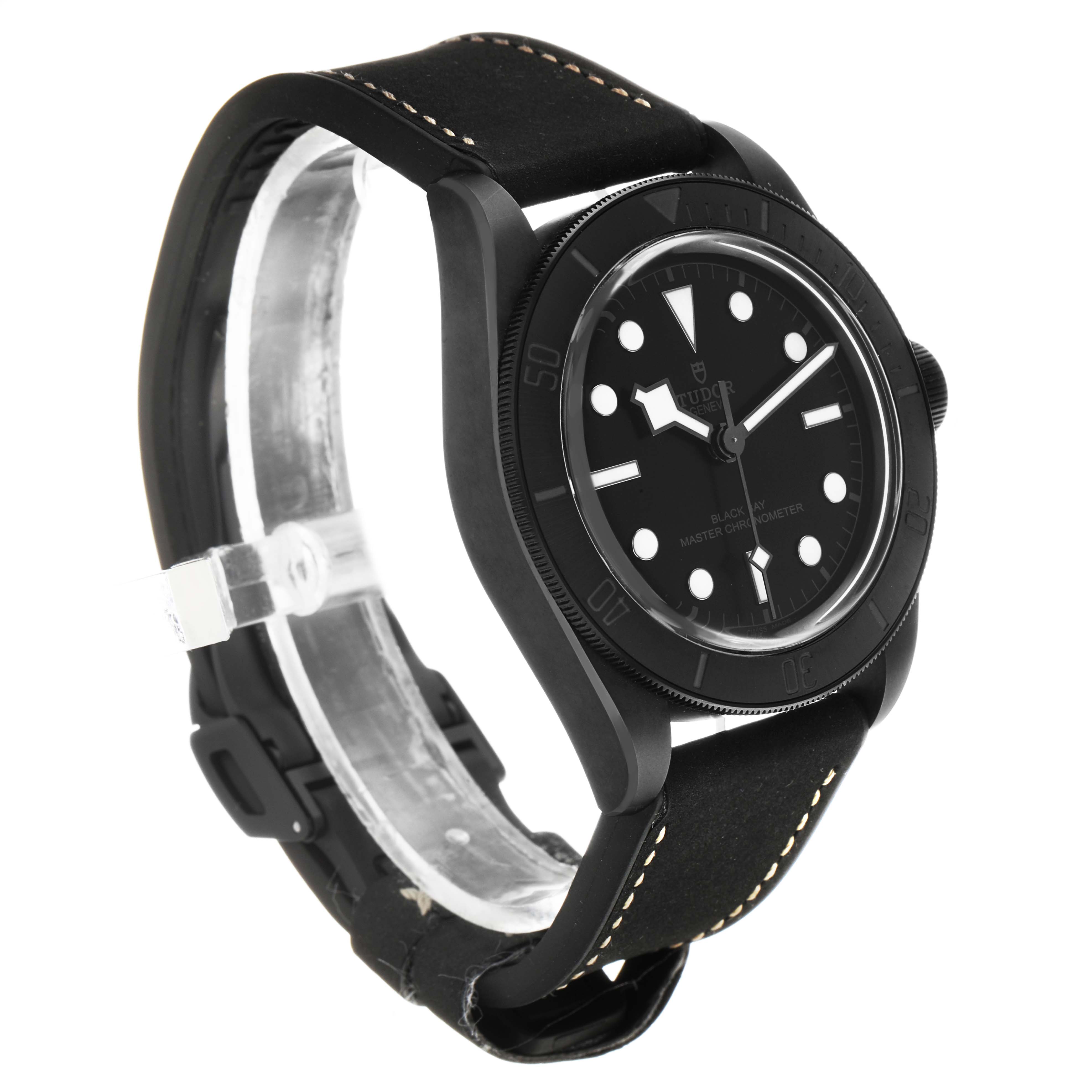 The Tudor Heritage Black Bay 79210 Men's Ceramic Black Dial watch is shown at a three-quarter angle, highlighting its black dial, bezel, and leather strap.