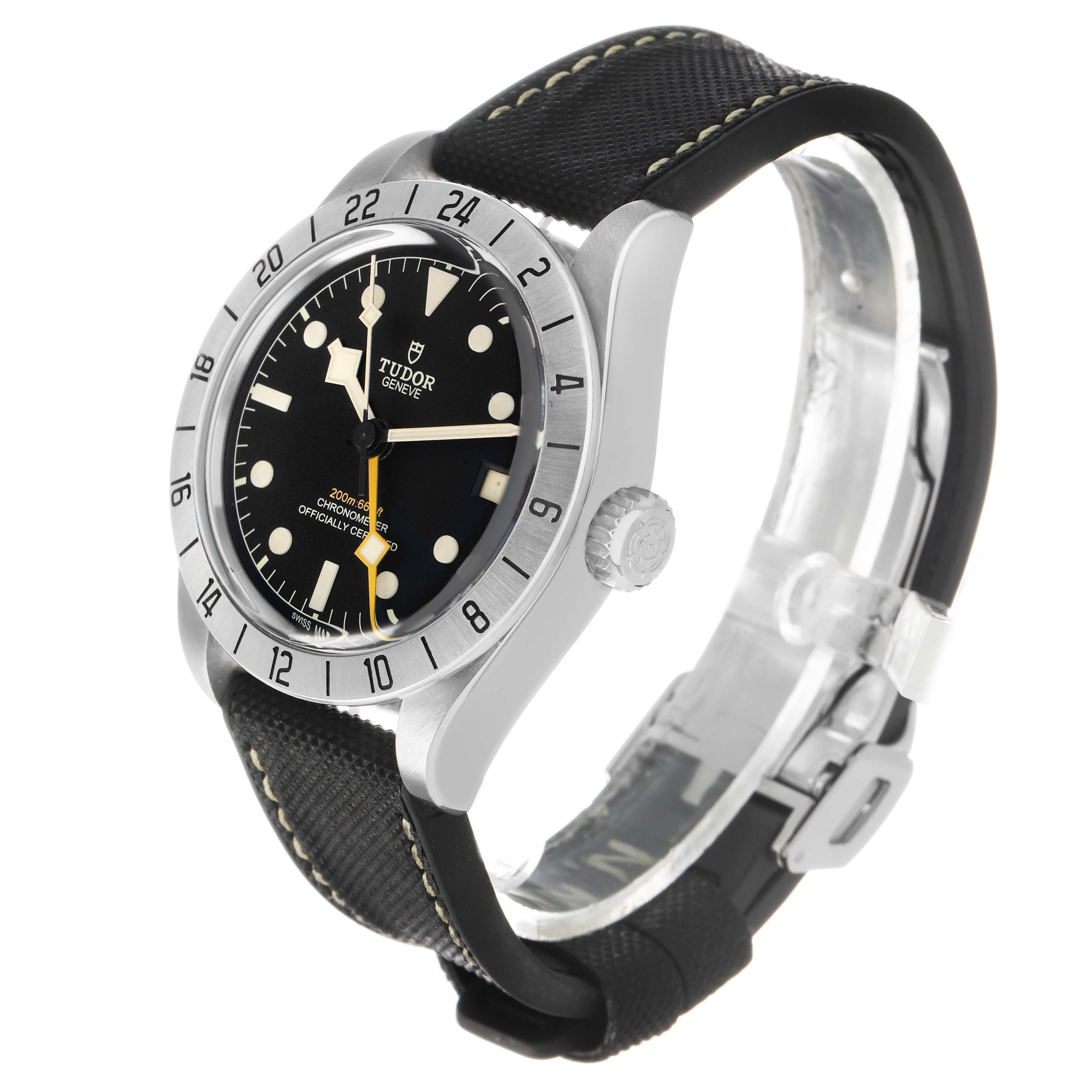 The Tudor Heritage Black Bay 79470 Men's Stainless Steel Black Dial watch is shown at a three-quarter angle, highlighting the bezel, crown, and face.