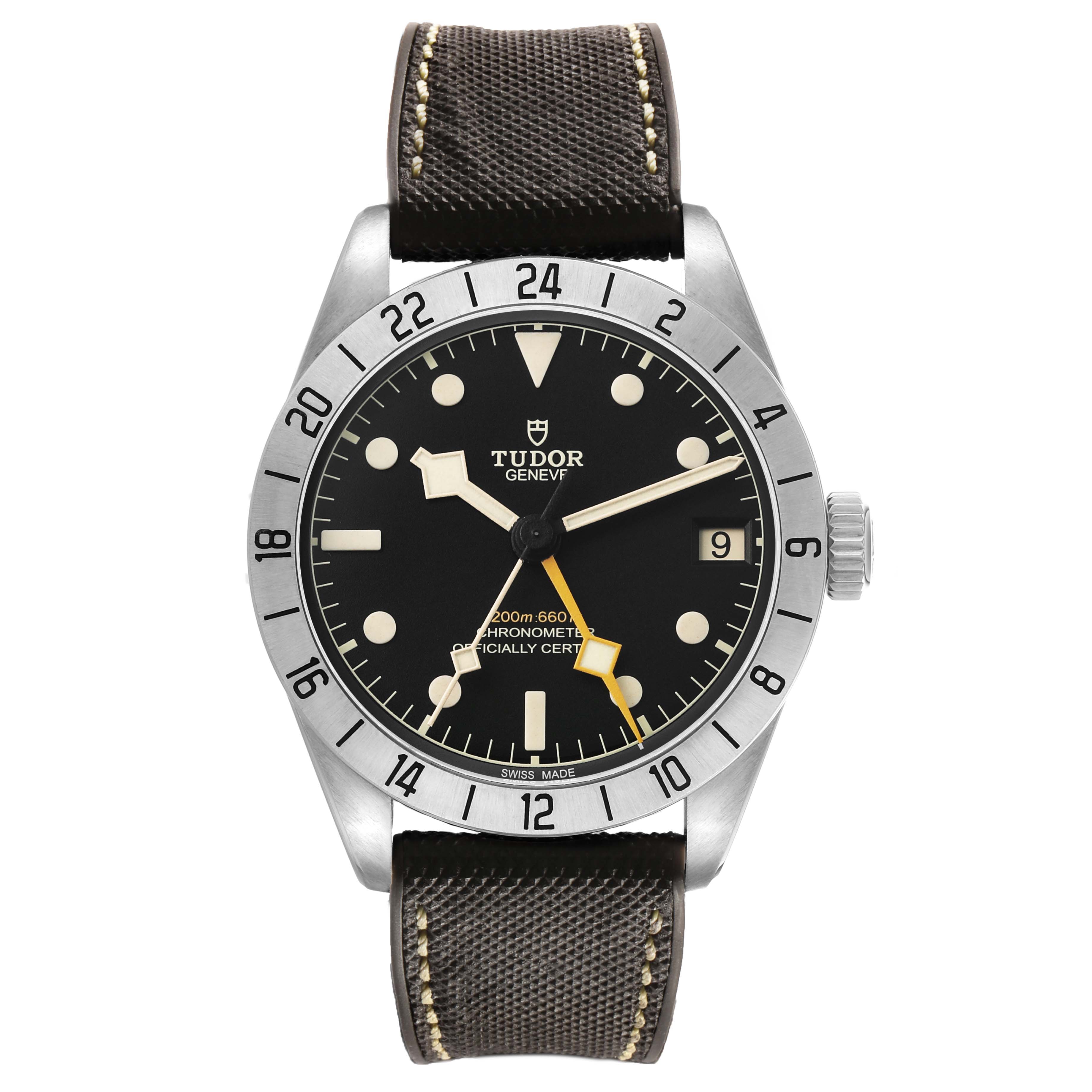 The Tudor Heritage Black Bay 79470 Men's Stainless Steel Black Dial watch is shown from a front angle, displaying its dial, bezel, crown, and strap.