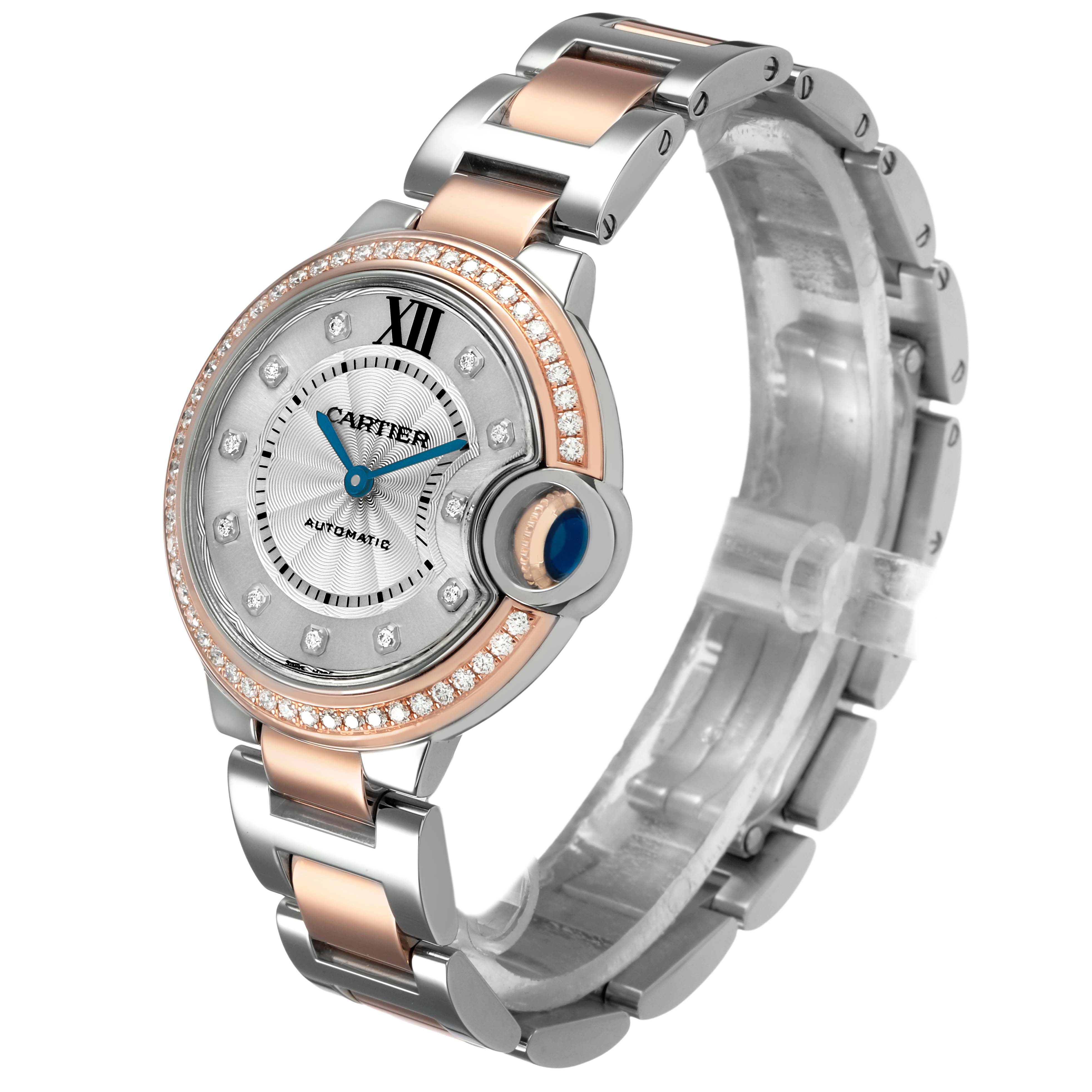 The Cartier Ballon Bleu WE902077 Women's Steel and Gold (two tone) Silver Dial watch is shown at a three-quarter angle, highlighting its two-tone bracelet, diamond bezel, and blue cabochon crown.