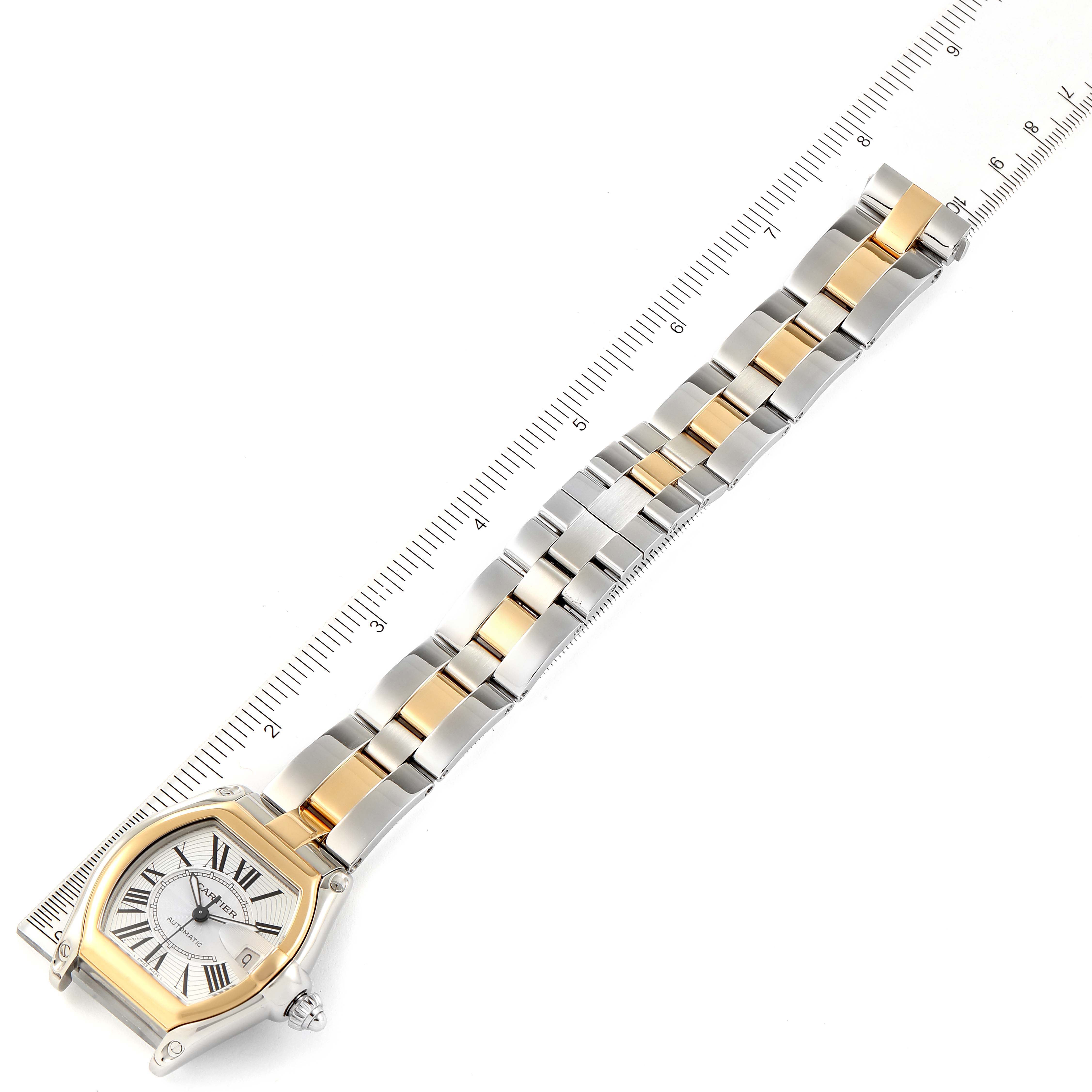 The image shows a Cartier Roadster W62031Y4 Men's Steel and Gold (two tone) Silver Dial W62031Y4 Men's Steel and Gold (two tone) Silver Dial watch and its metal bracelet laid flat with a ruler for measurement.
