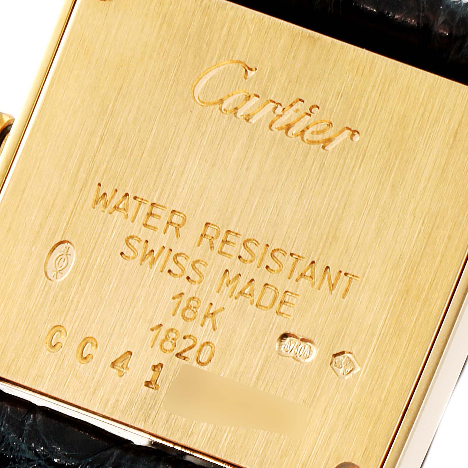 The image shows the back case of a Cartier Tank Francaise W5000256 Women's Yellow Gold Silver Dial W5000256 Women's Yellow Gold Silver Dial watch, highlighting its engravings and material.