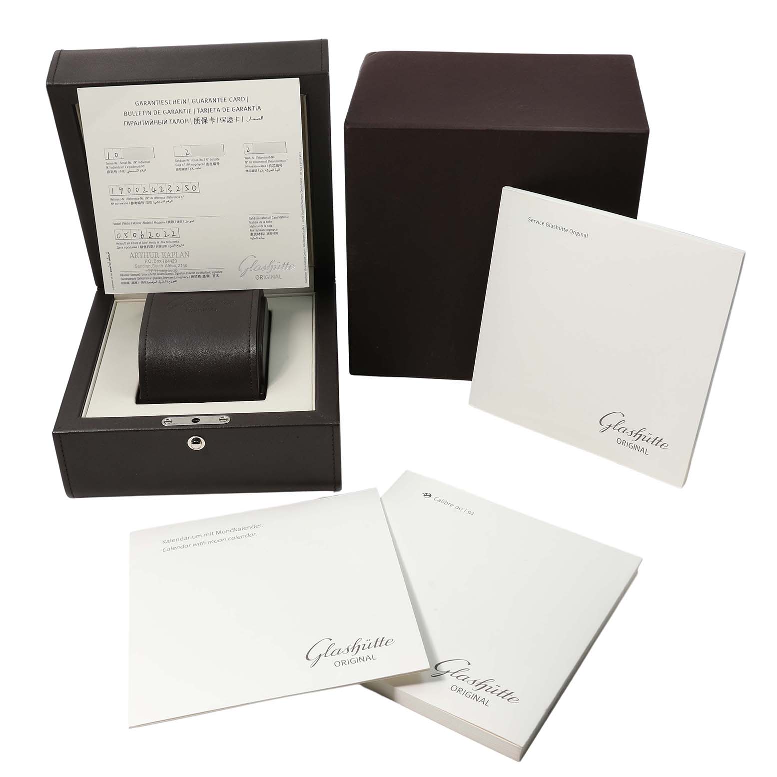 The image shows the Glashütte Pano watch packaging, with an open box displaying documents and a cushion for the watch.